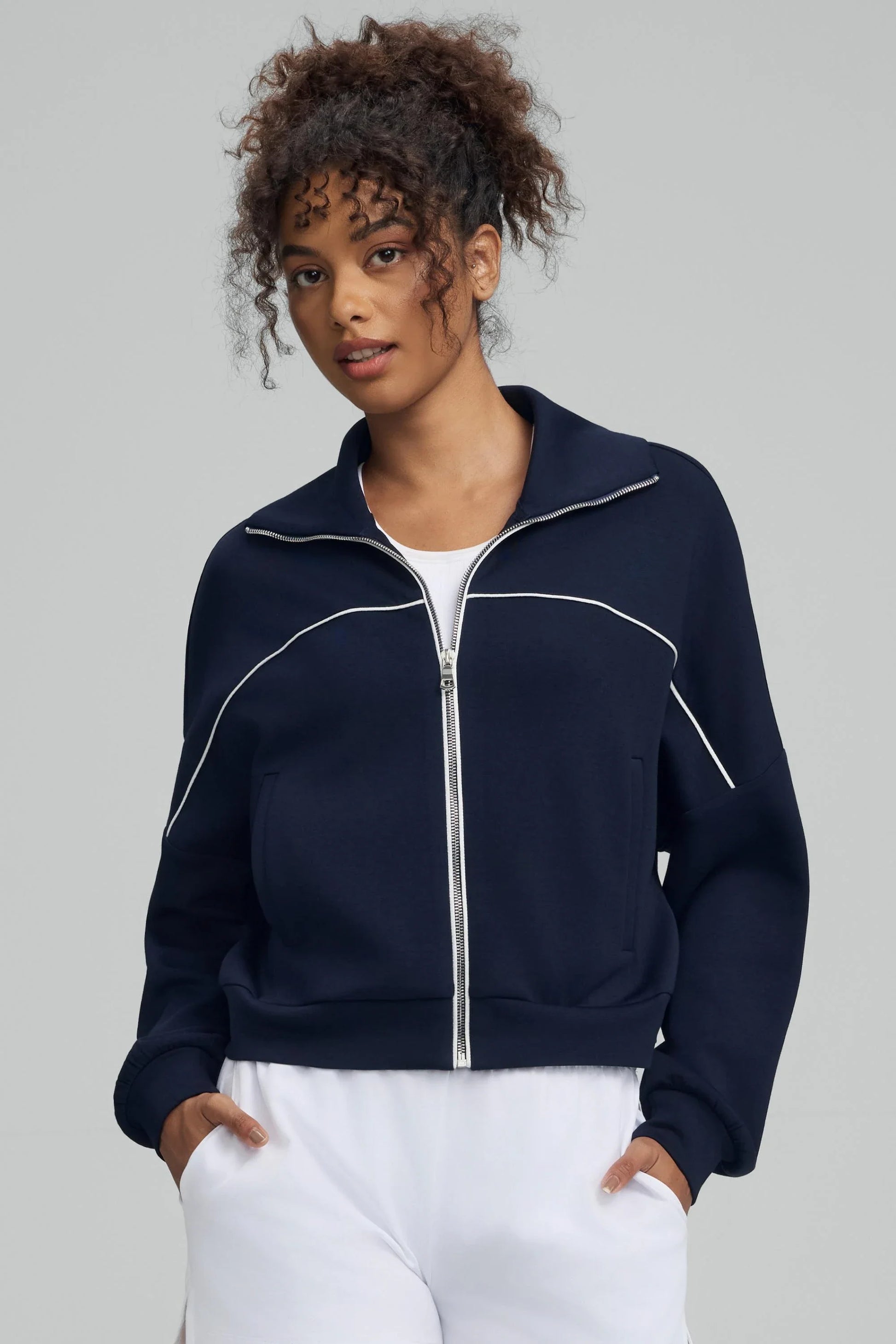 Women’s cropped golf jacket in midnight navy with a zip-front collar and contrast piping detail