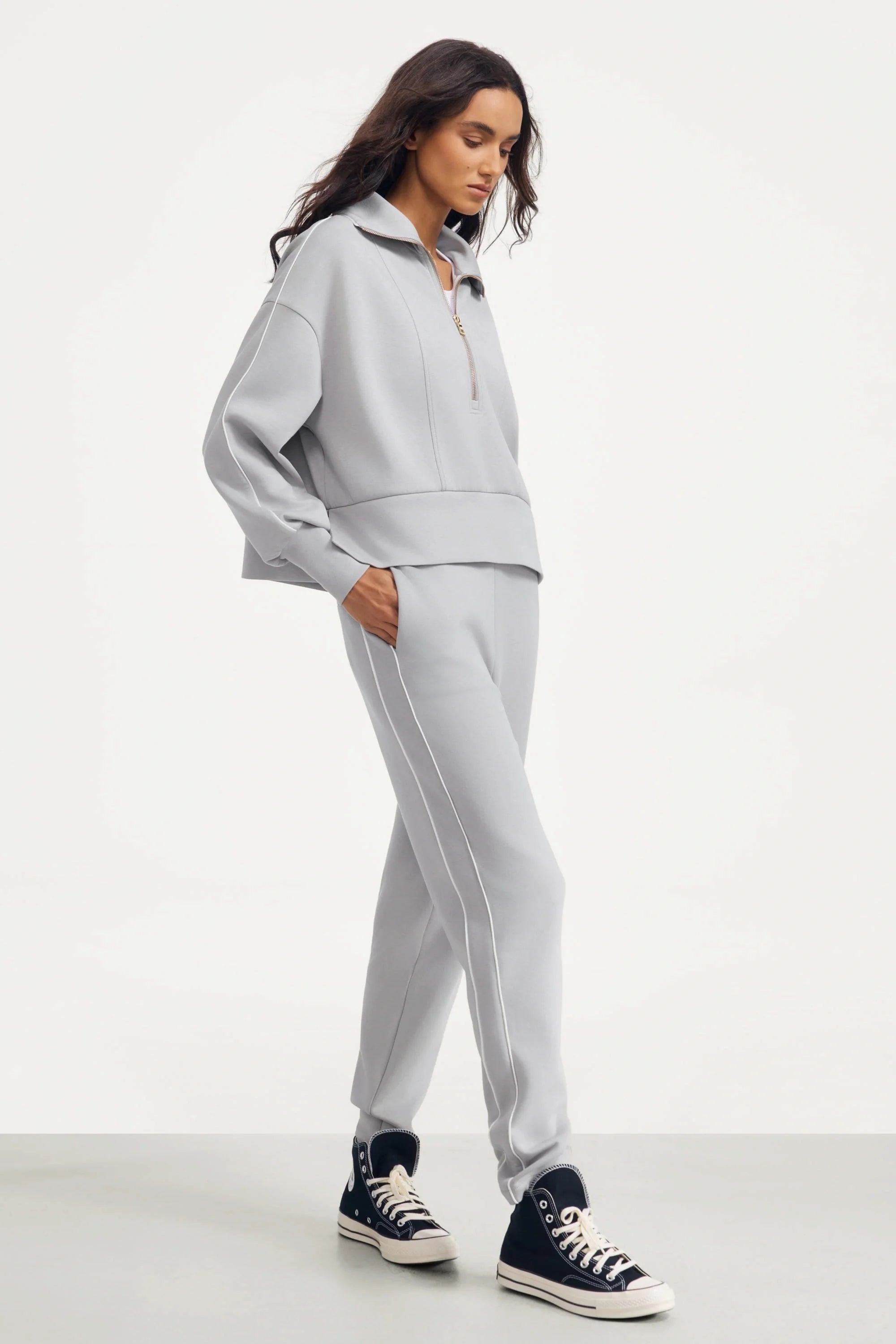 Side view of women's Soft Cloud Grey slim fit golf pants styled with a matching top