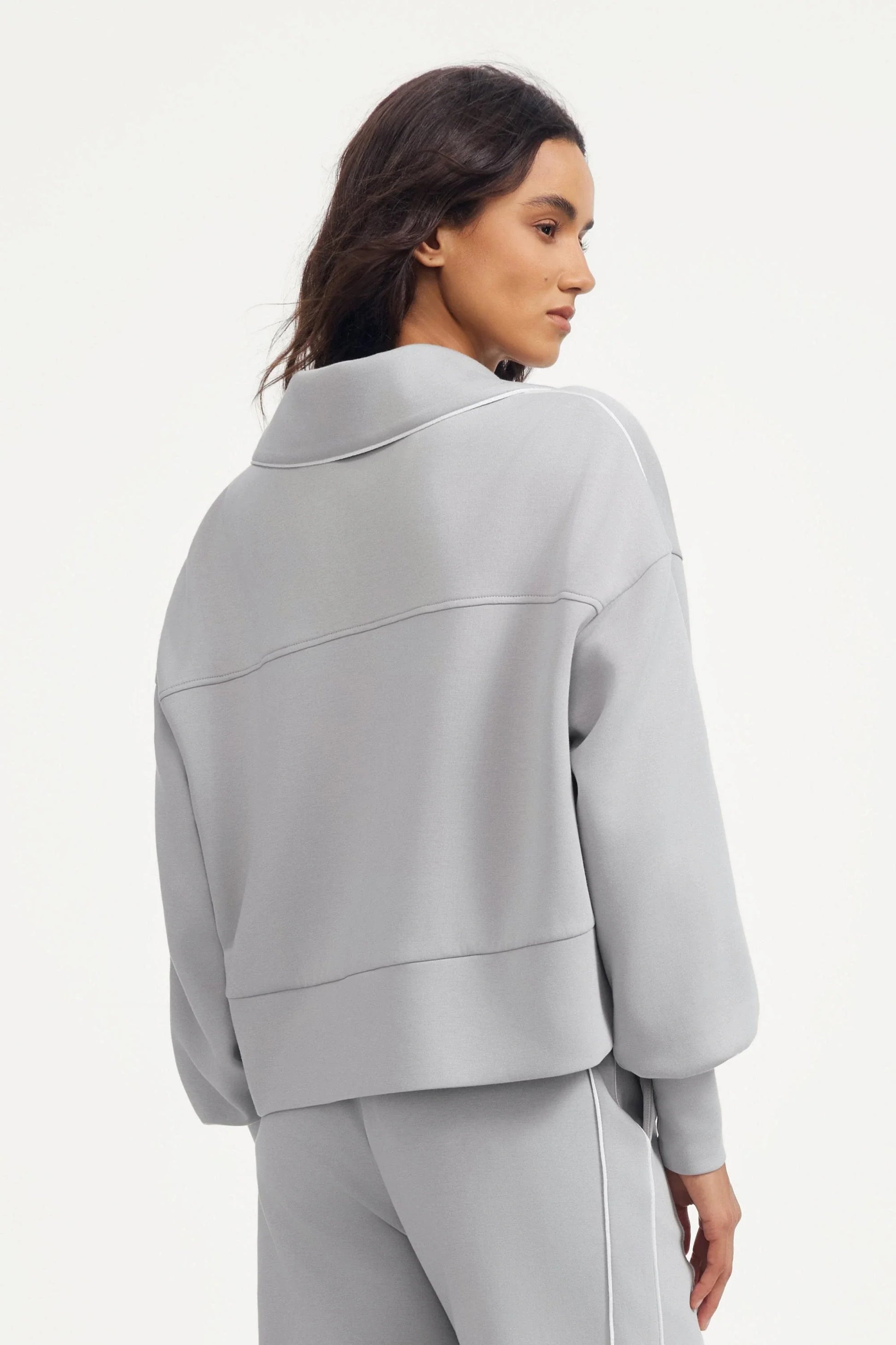 Back view of a women’s half-zip golf pullover in Soft Cloud Grey with dropped shoulder design