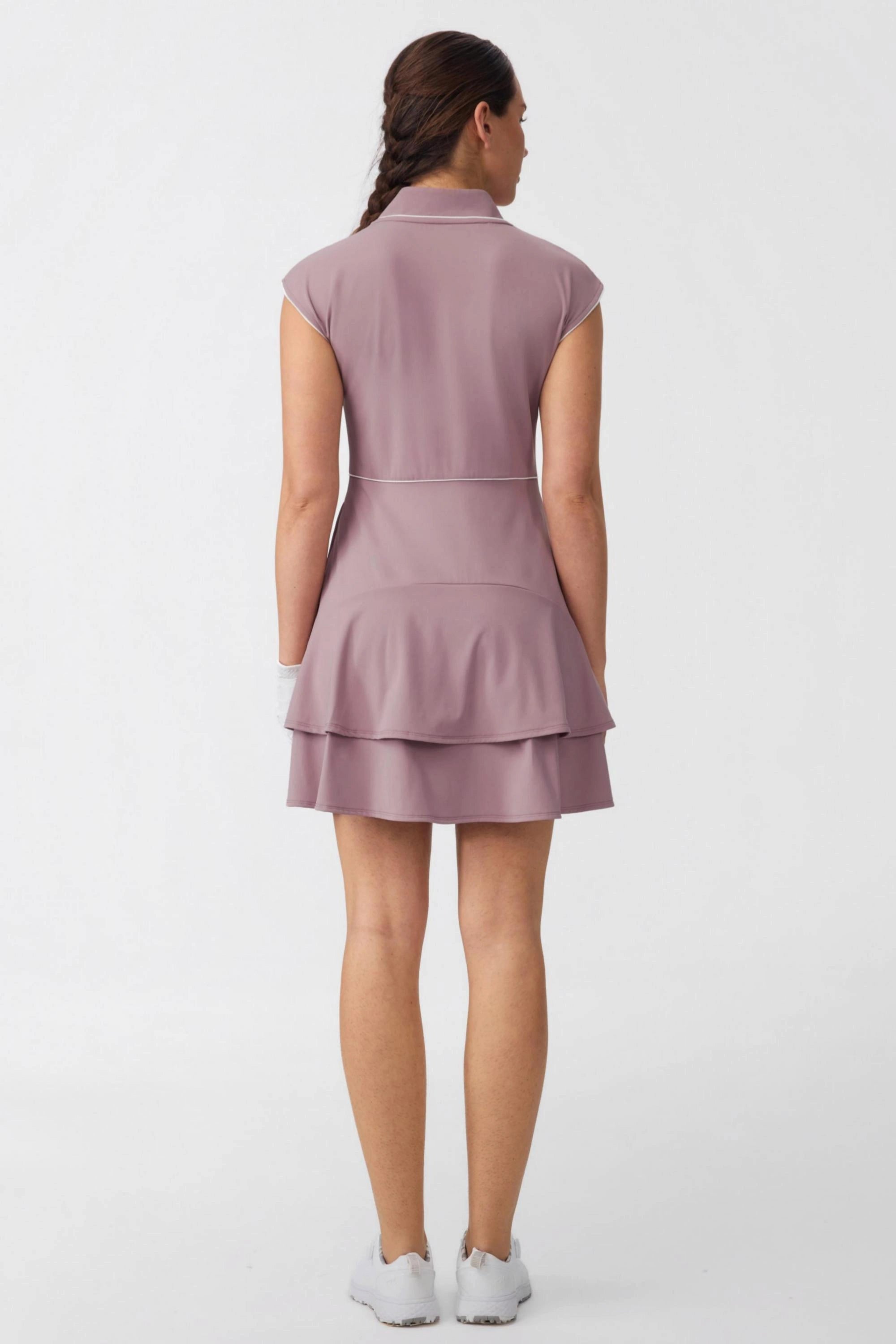 Back view of women's mauve golf dress with cap sleeves and layered skirt