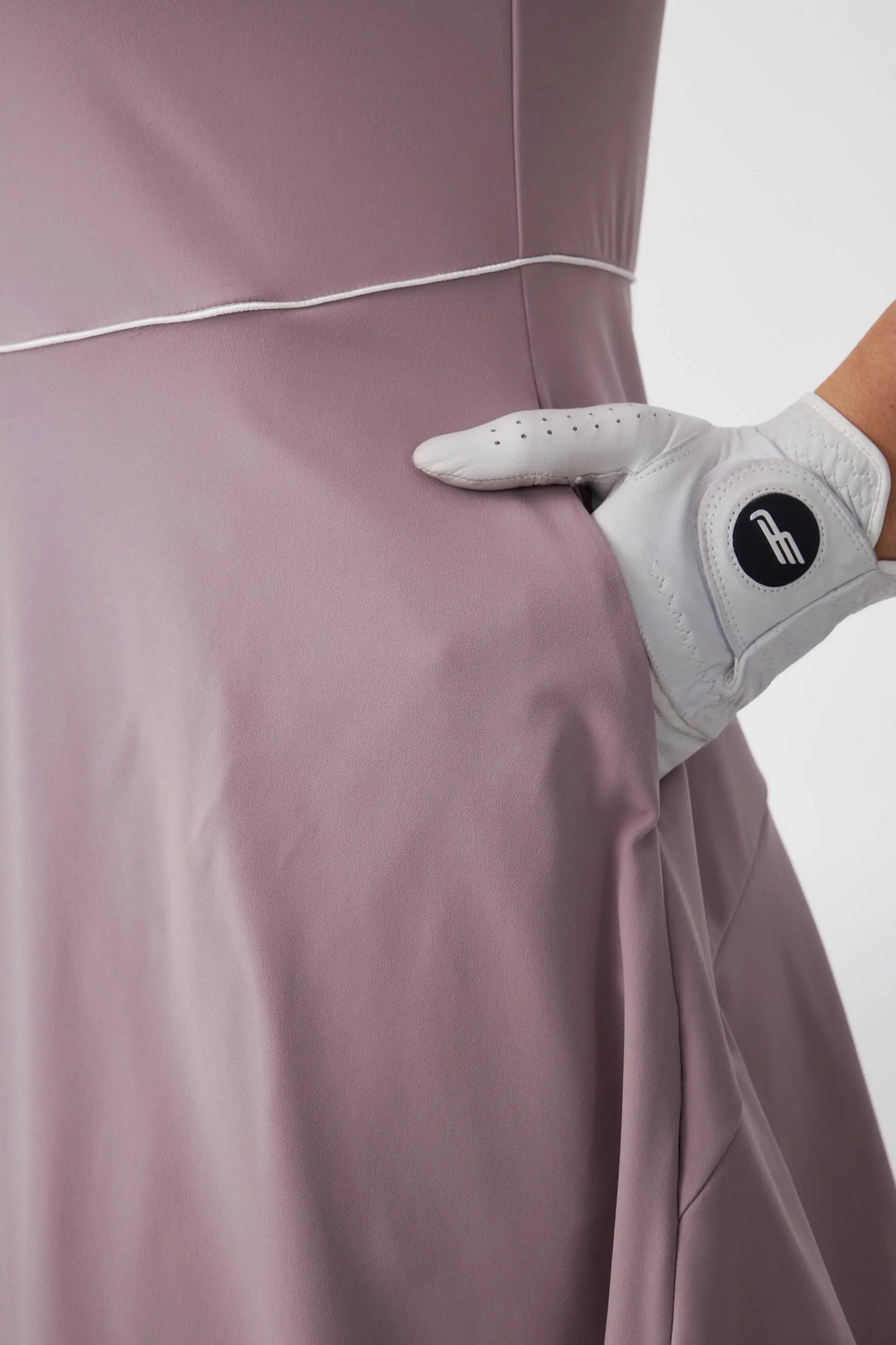 Close-up of the side pocket detail on a soft mauve golf dress