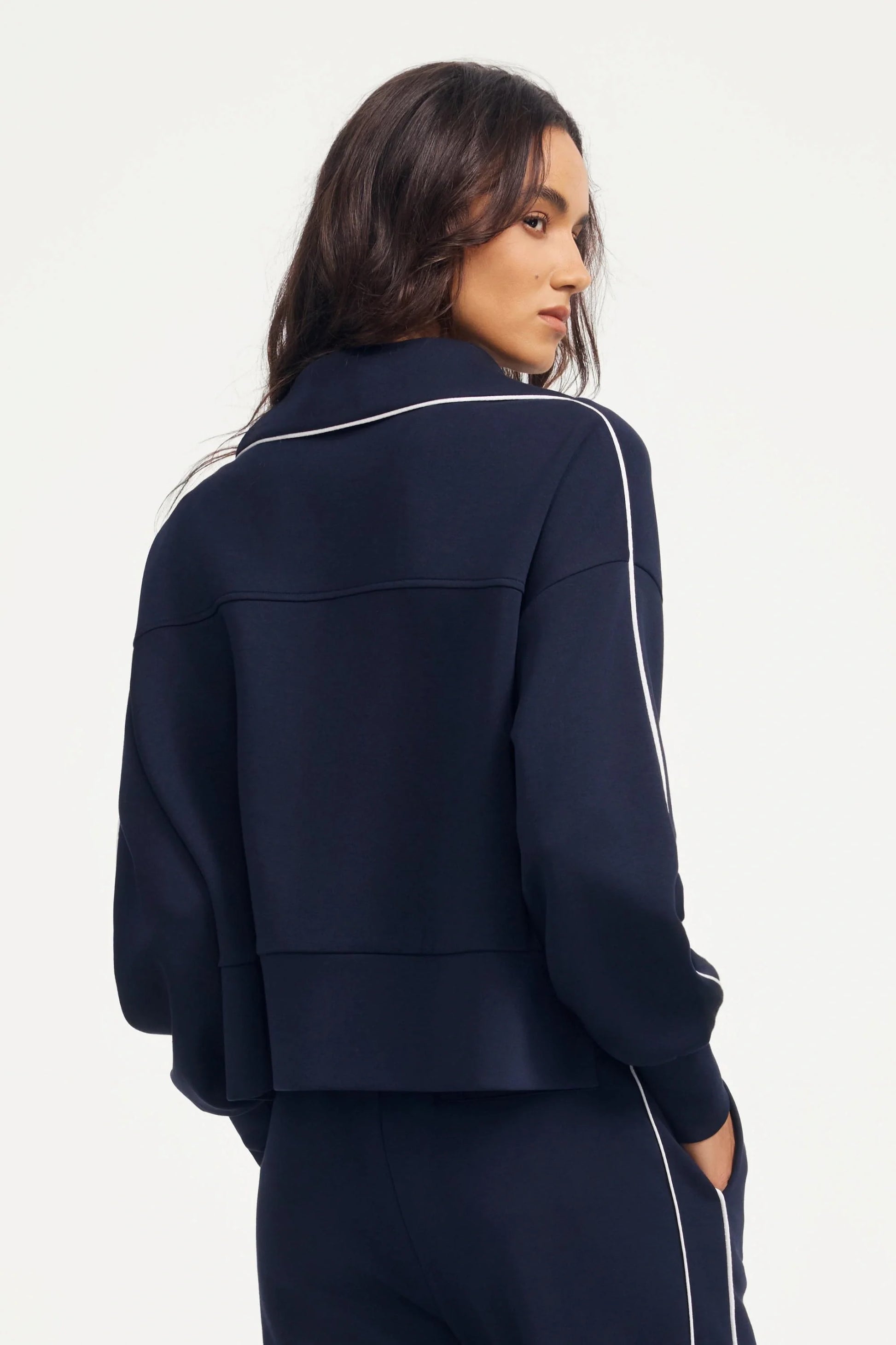 Back detail of a women’s half-zip golf pullover in Midnight Navy with contrast piping along the shoulders