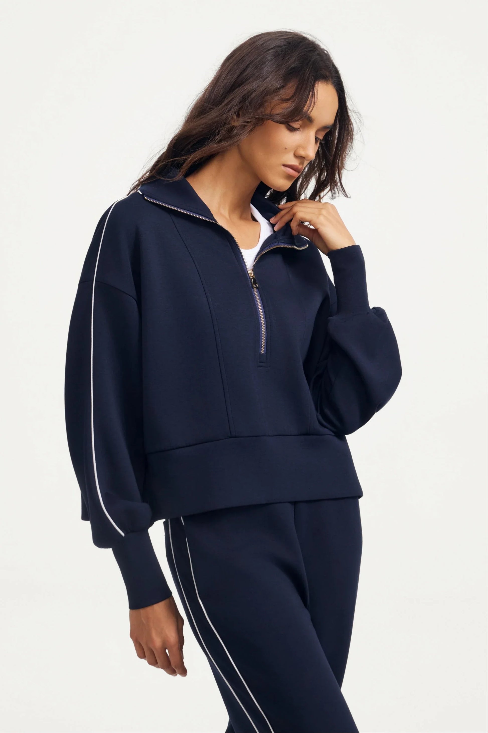 Woman wearing a women’s half-zip golf pullover in Midnight Navy with a relaxed silhouette and soft structure