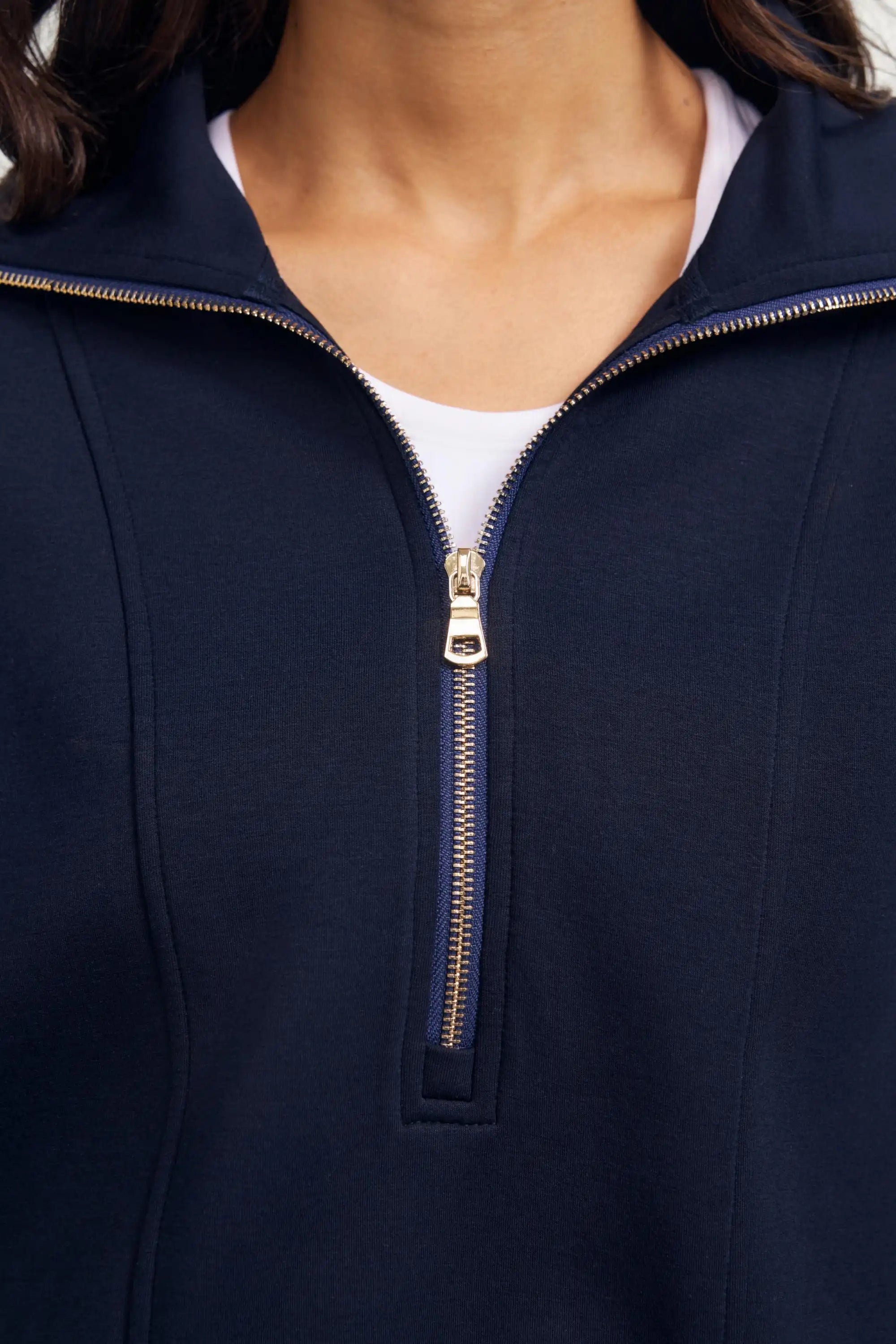 Close-up of the zipper detail on a women’s half-zip golf pullover in Midnight Navy with polished metal hardware