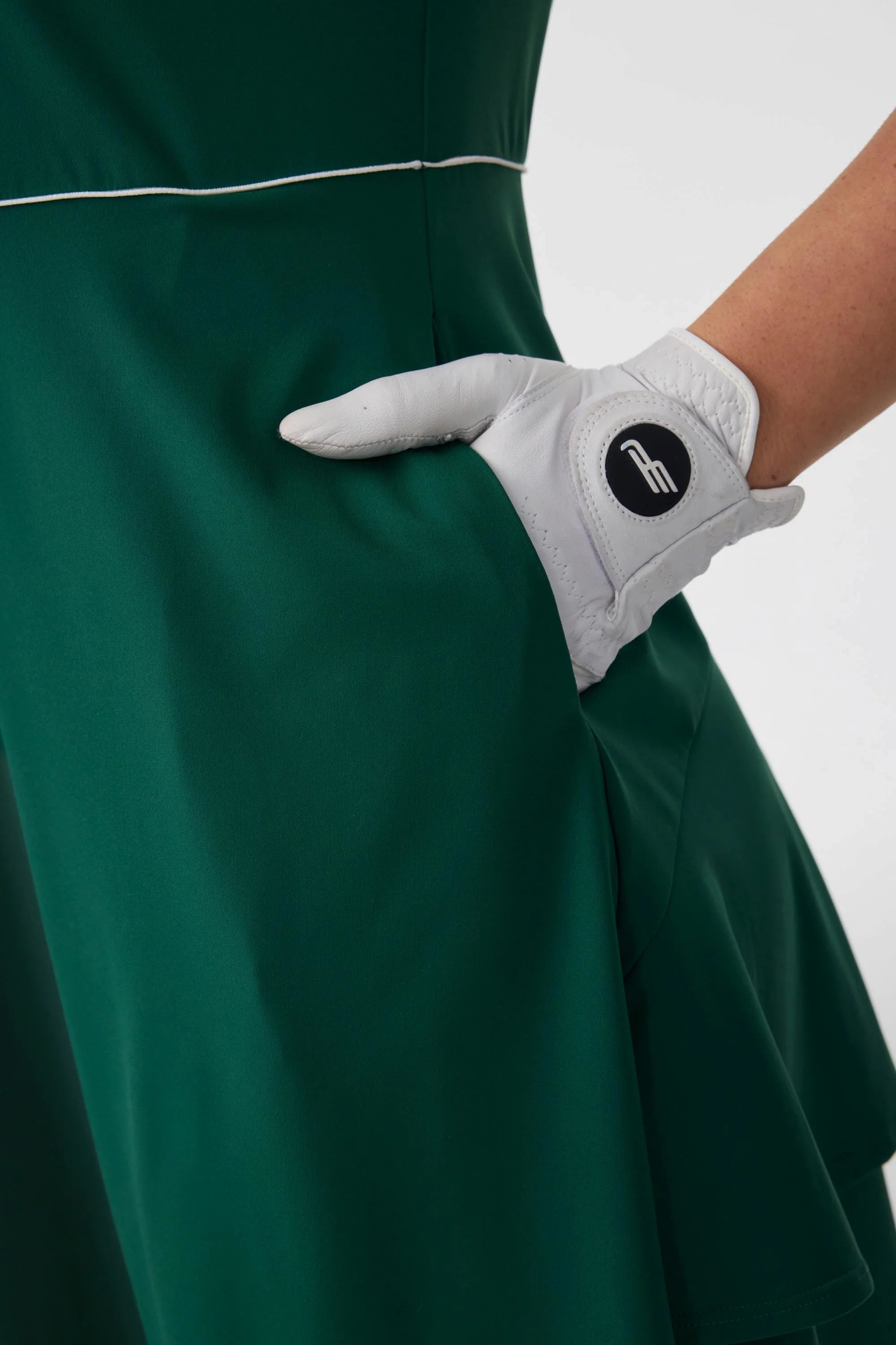 Close-up of the side pocket detail on a pine green golf dress