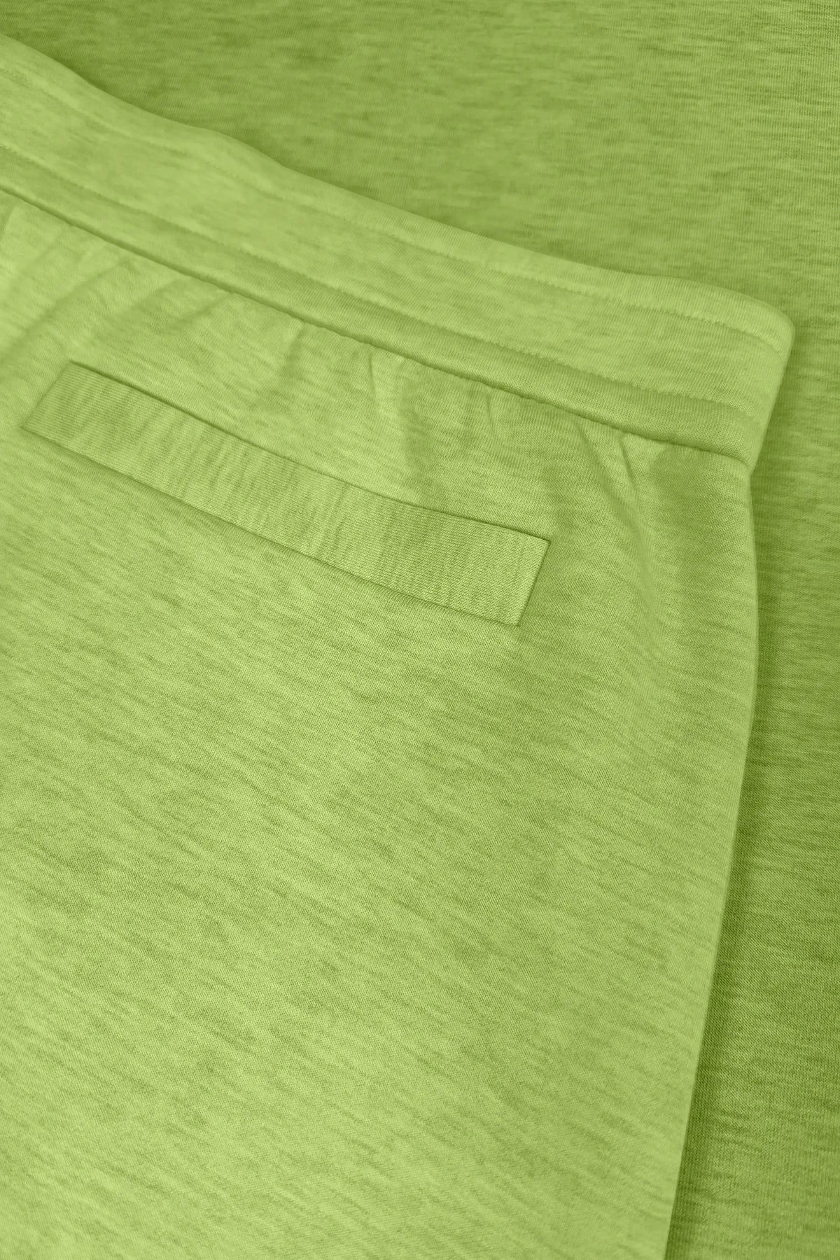 Close-up of lime Sculpt Wrap Golf Skort showing the back pocket and clean waistband detail