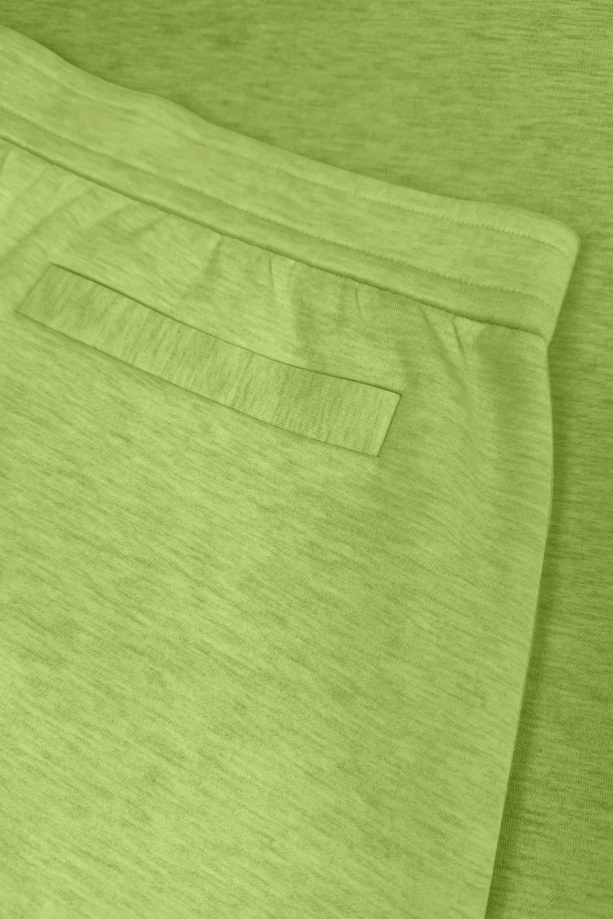 Close-up of lime Sculpt Wrap Golf Skort showing the back pocket and clean waistband detail