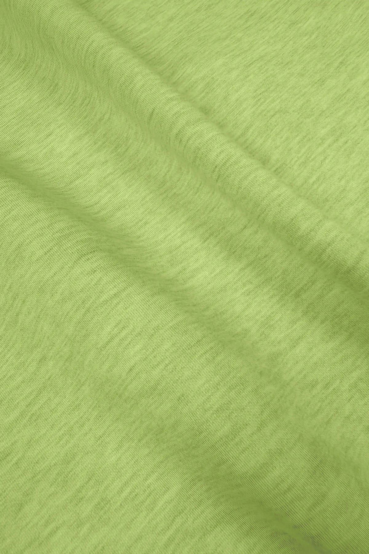 Close-up of lime Sculpt Wrap Golf Skort showing the soft stretch fabric texture and drape