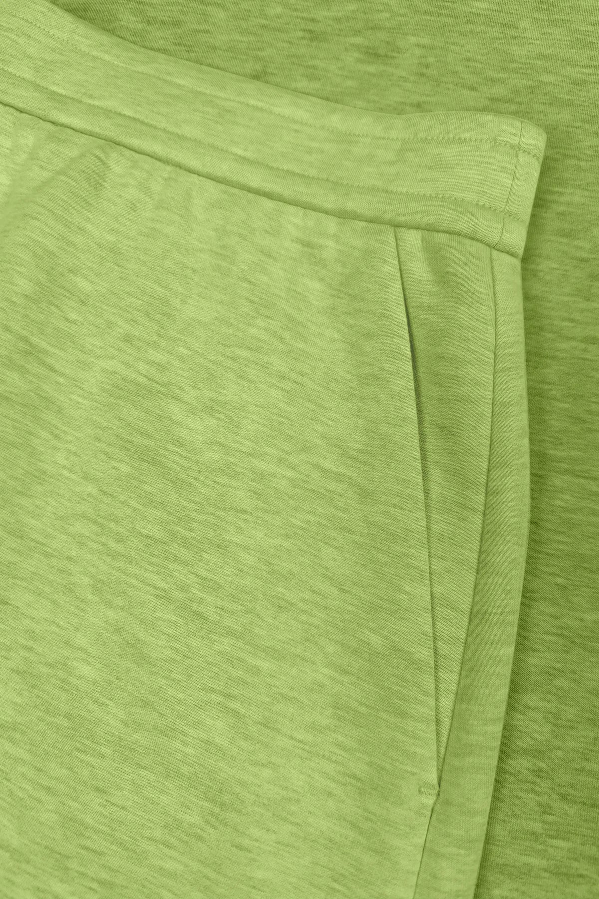 Close-up of lime Sculpt Wrap Golf Skort highlighting the side pocket and waistband construction