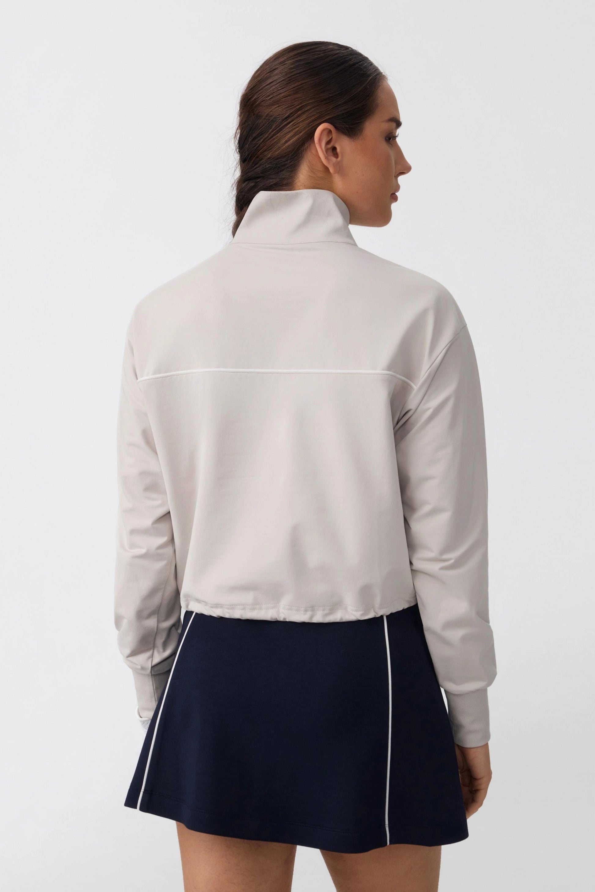 Back view of women's soft taupe long sleeve golf top