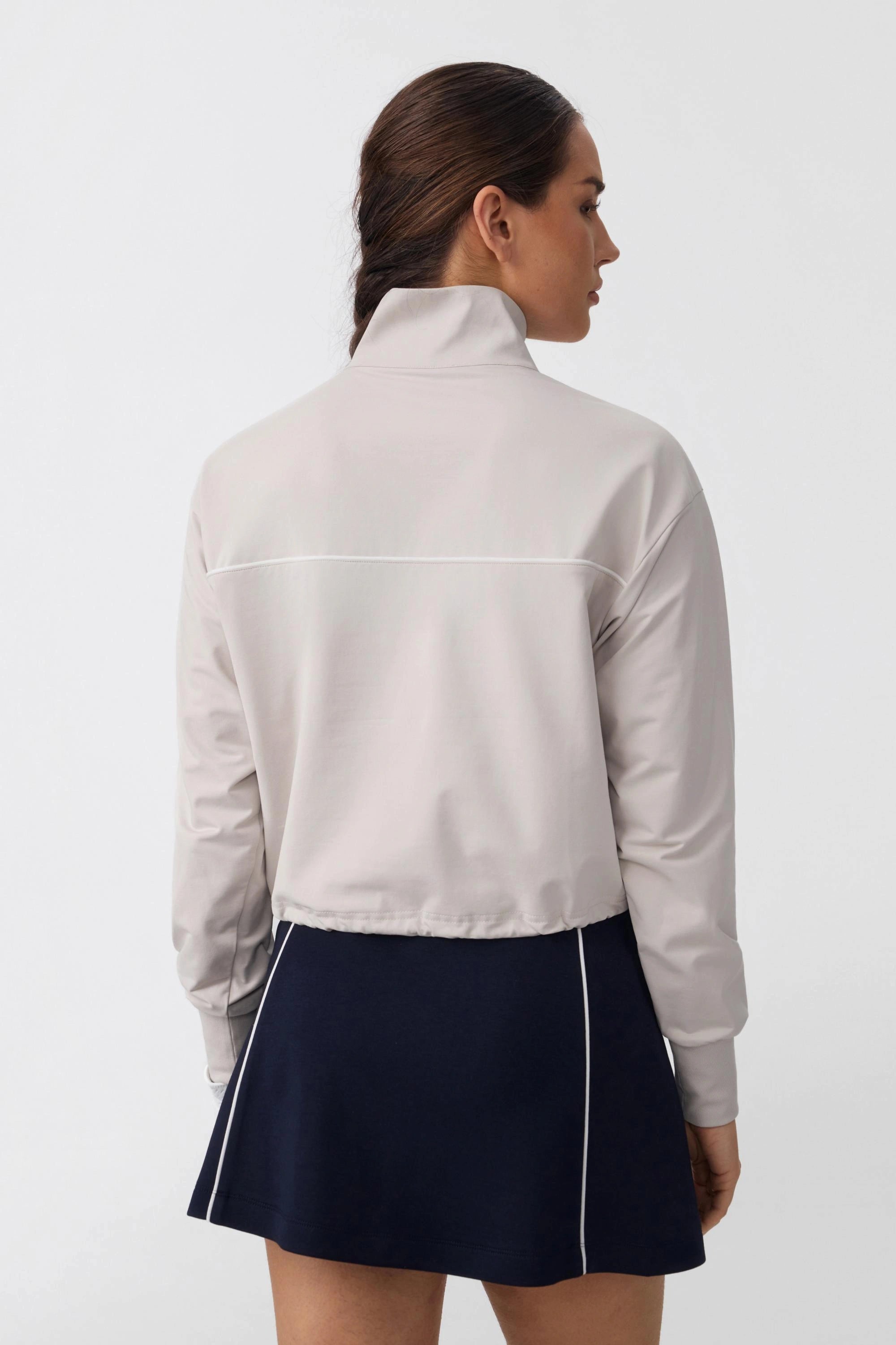 Back view of women's soft taupe long sleeve golf top