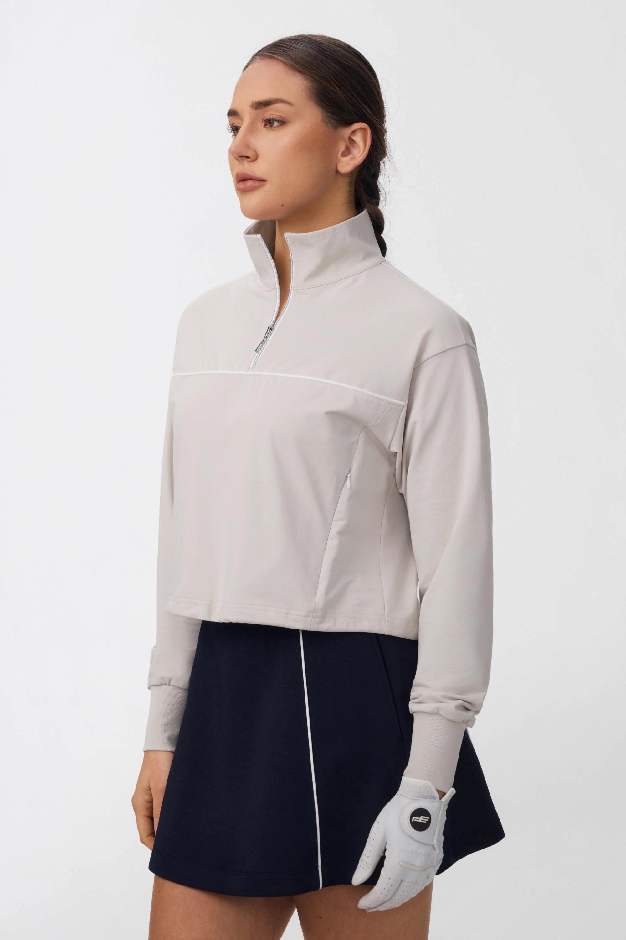 Side view of women's soft taupe long sleeve half-zip golf top