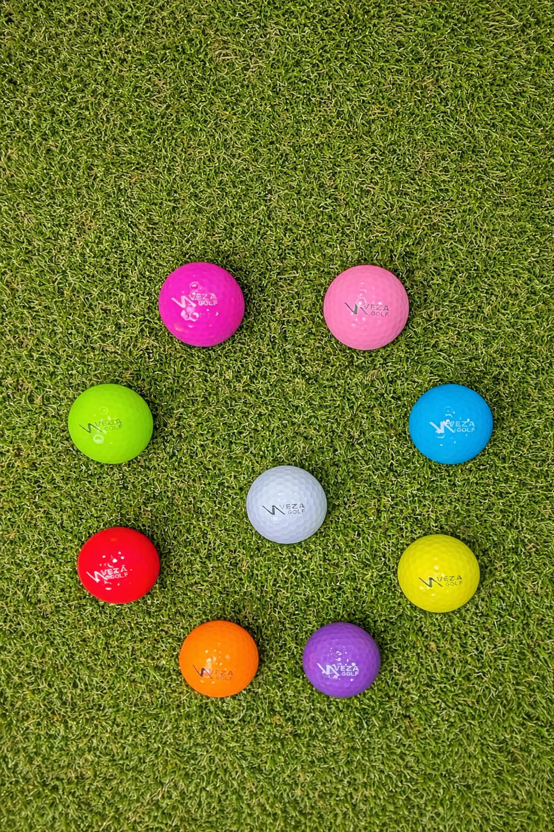 VEZA colored surlyn golf balls arranged in a circle on a golf course green