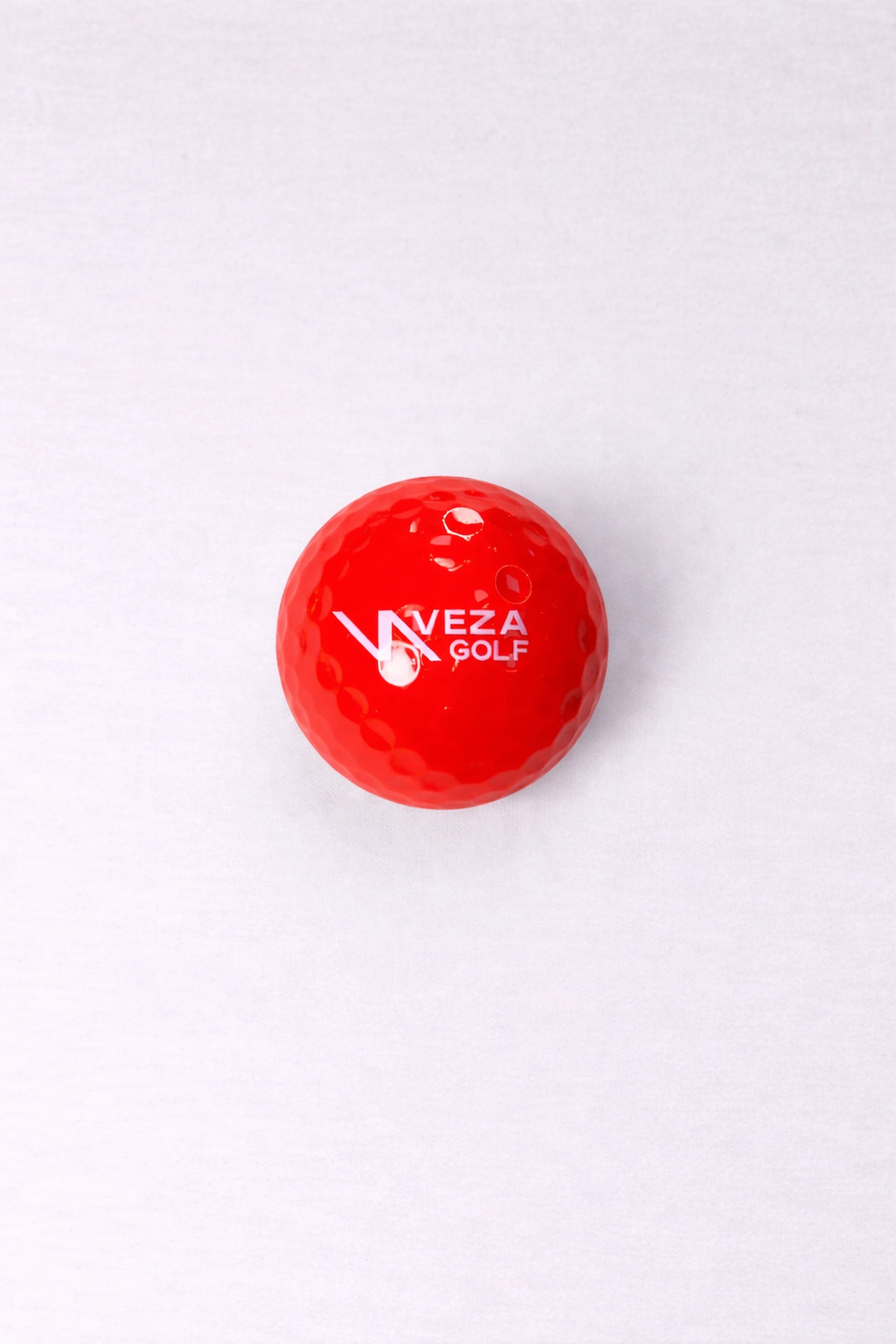 Red VEZA surlyn golf ball with brand logo