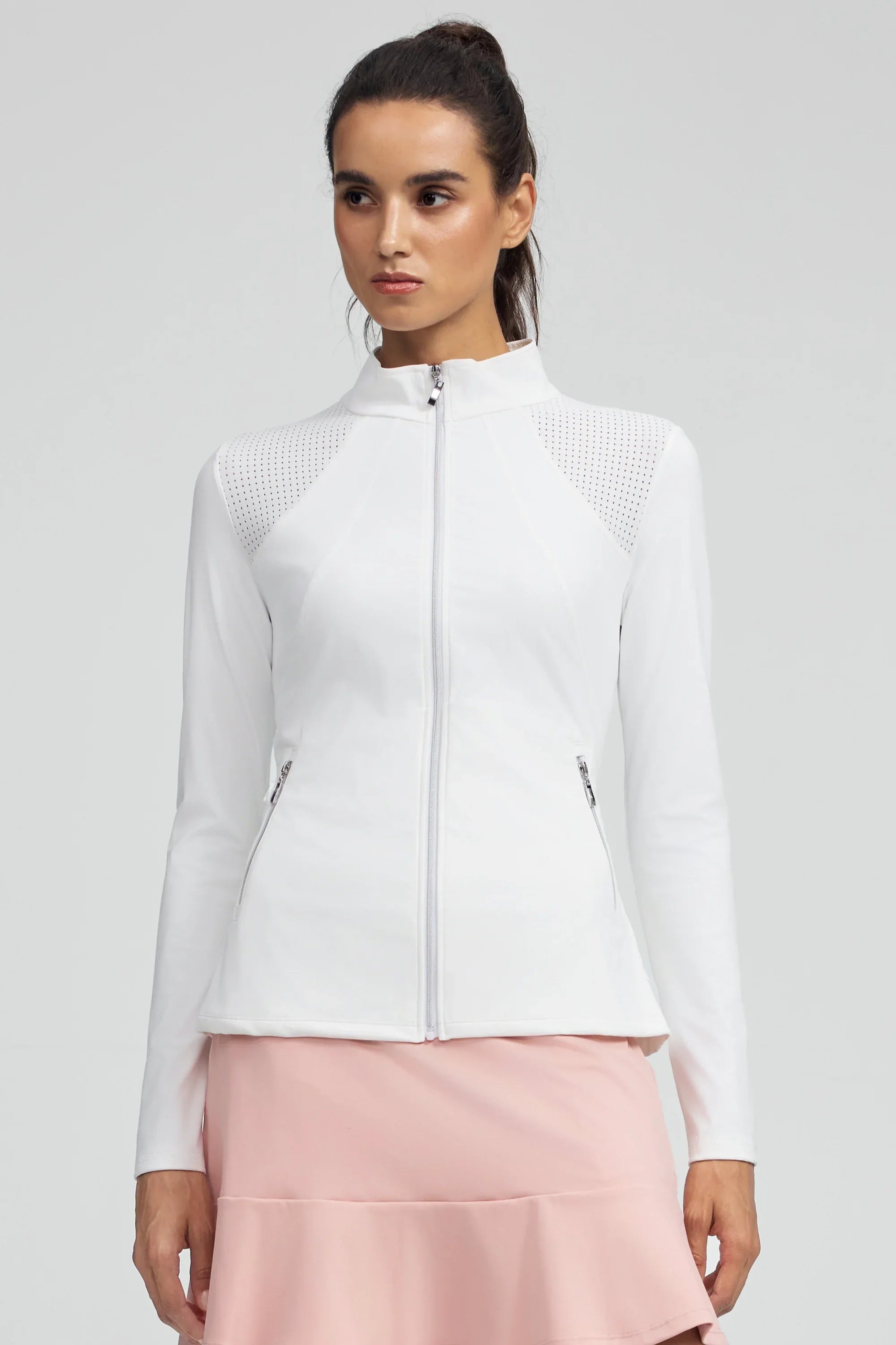 Woman wearing VEZA white peplum mesh-panel zip jacket with UPF 50+, styled with a pink athletic skirt, front view