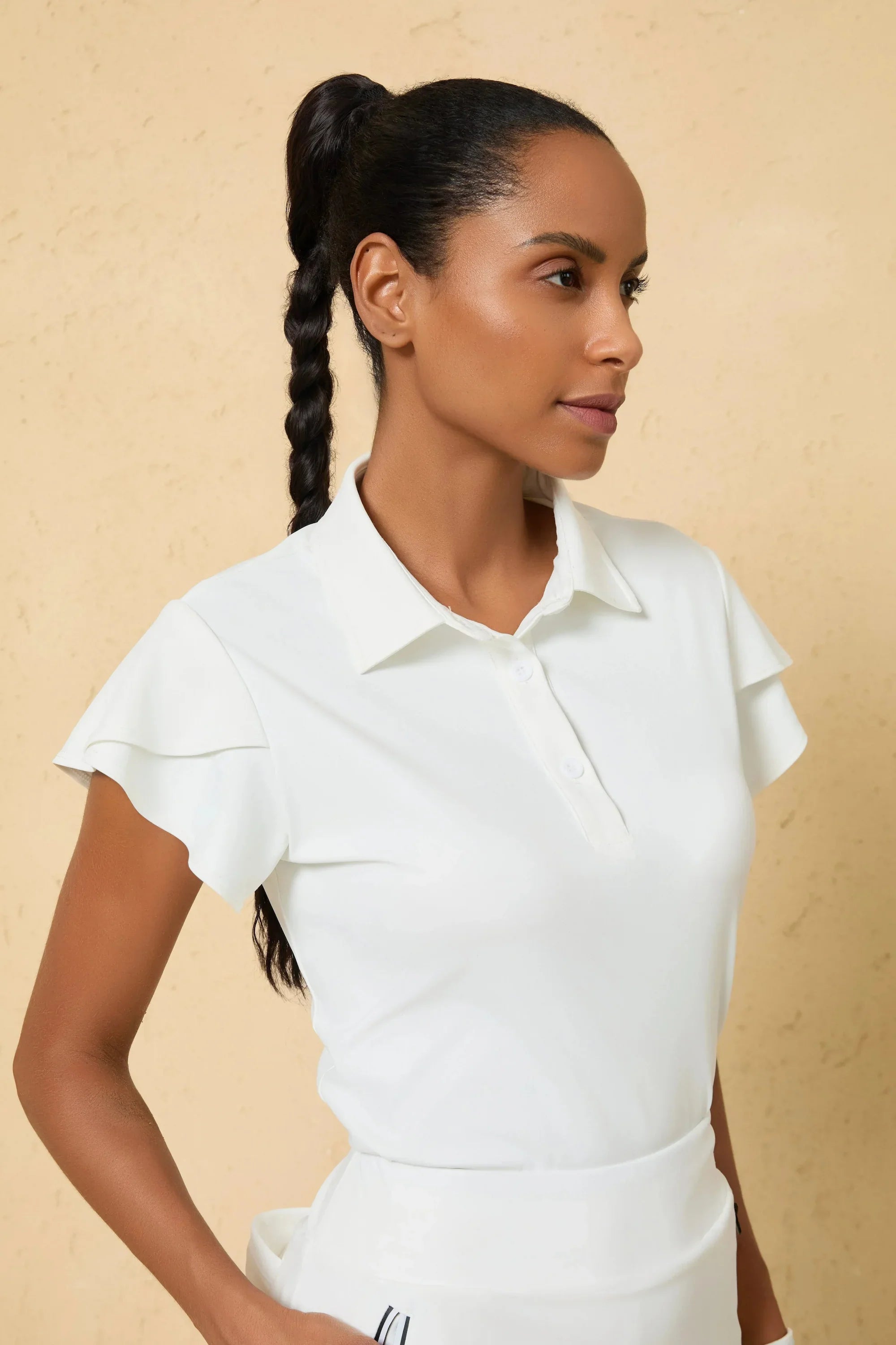 Close-up of VEZA cloudline white performance golf polo highlighting the ruffle sleeve and breathable collar detail