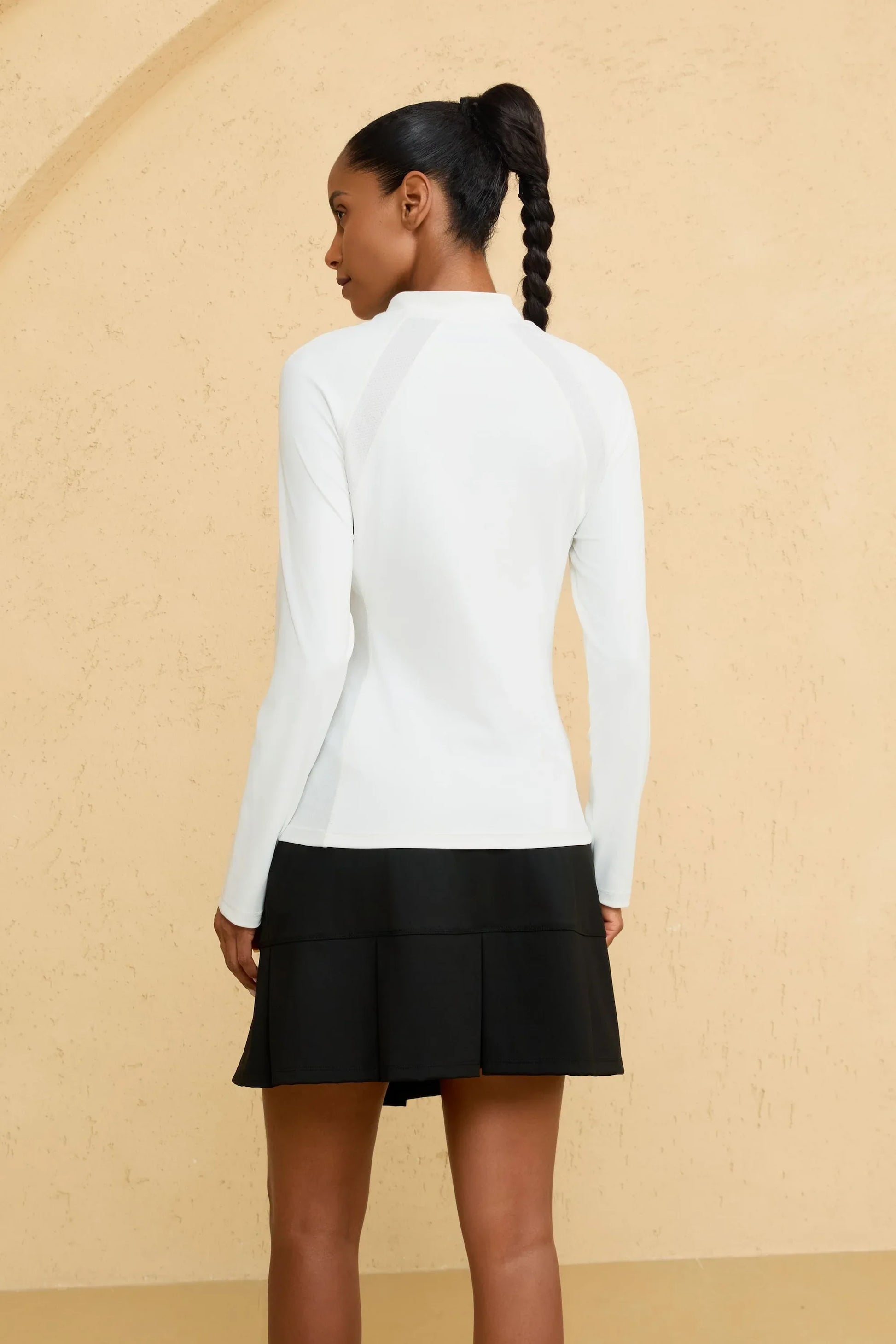 Back view of VEZA women’s cloud white mock-neck performance top featuring a clean, seamless silhouette
