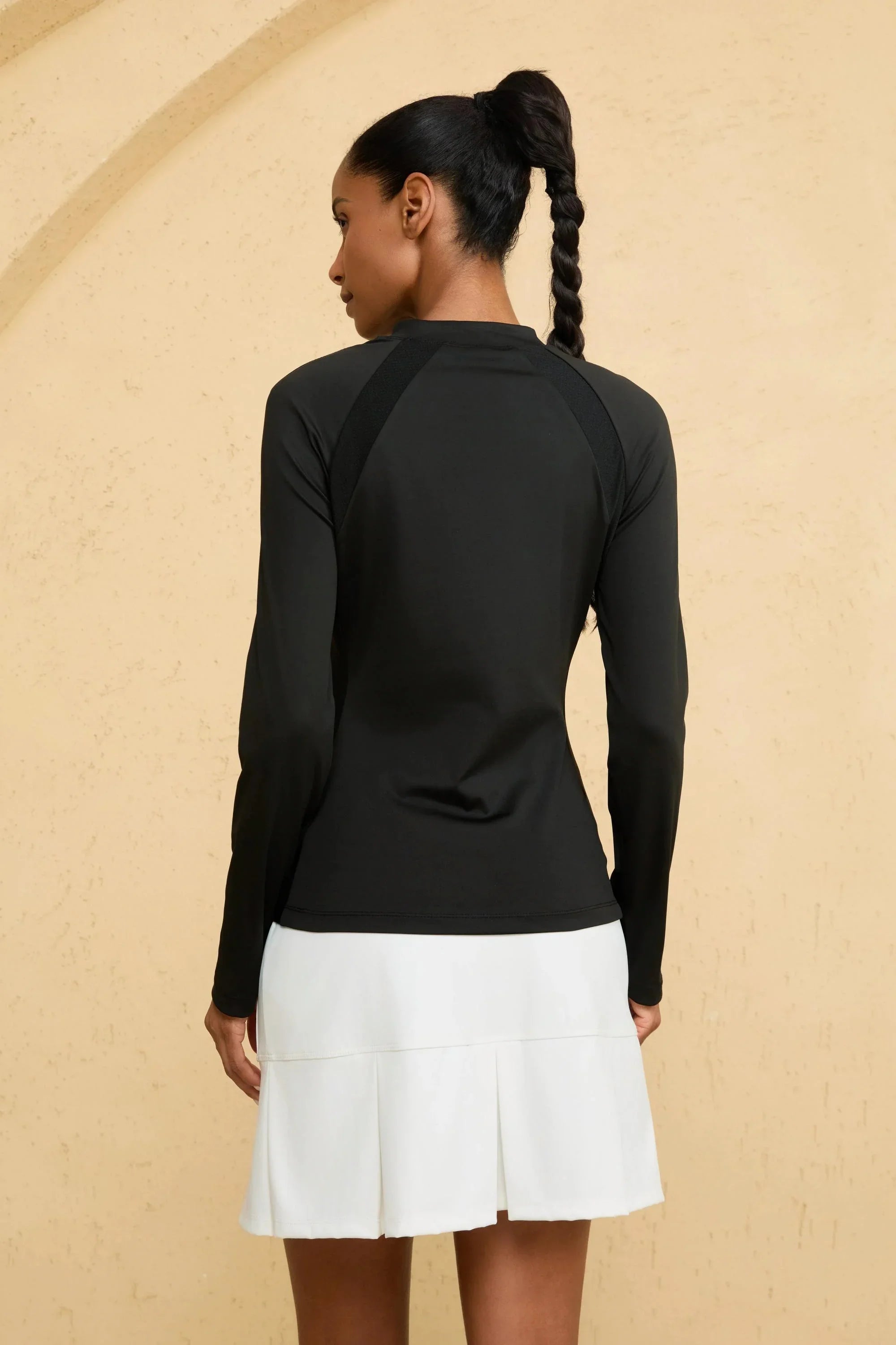 Back view of VEZA women’s black mock-neck performance top with seamless design and UPF 50+ protection