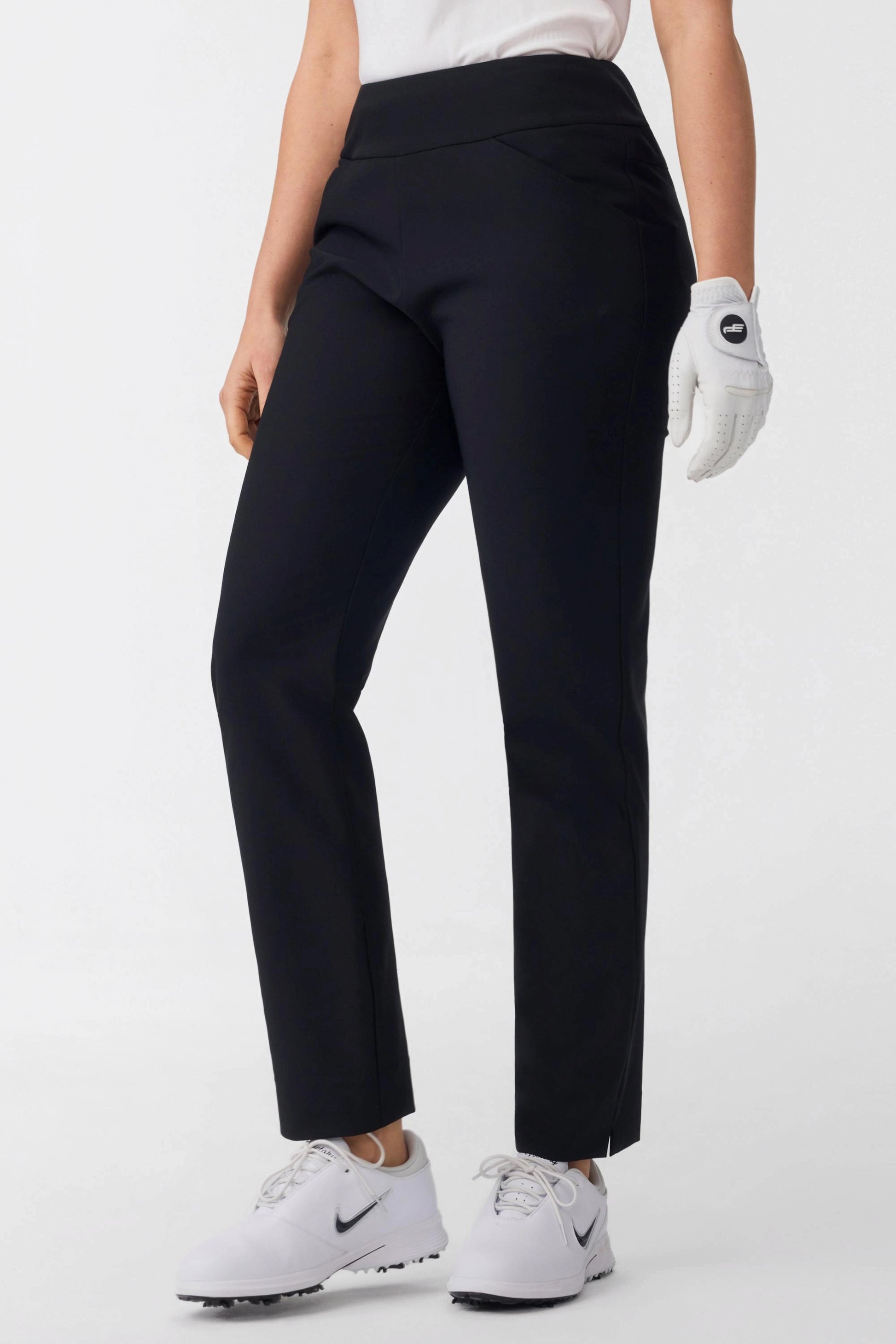 Front detail view of women’s onyx black tapered golf pants with pull-on waistband