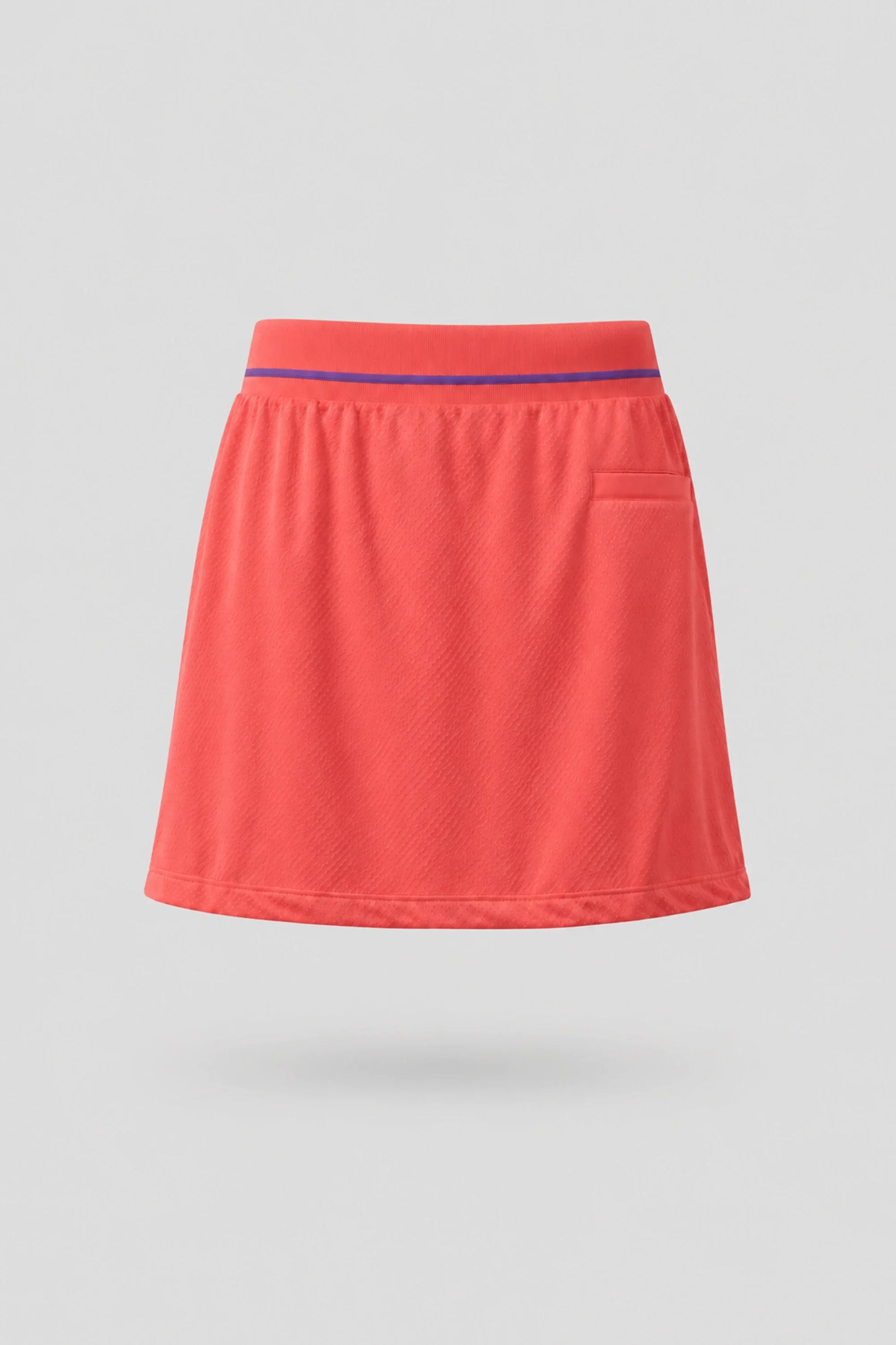 Back view of women's coral red golf skort with lightweight stretch fabric and flattering fit