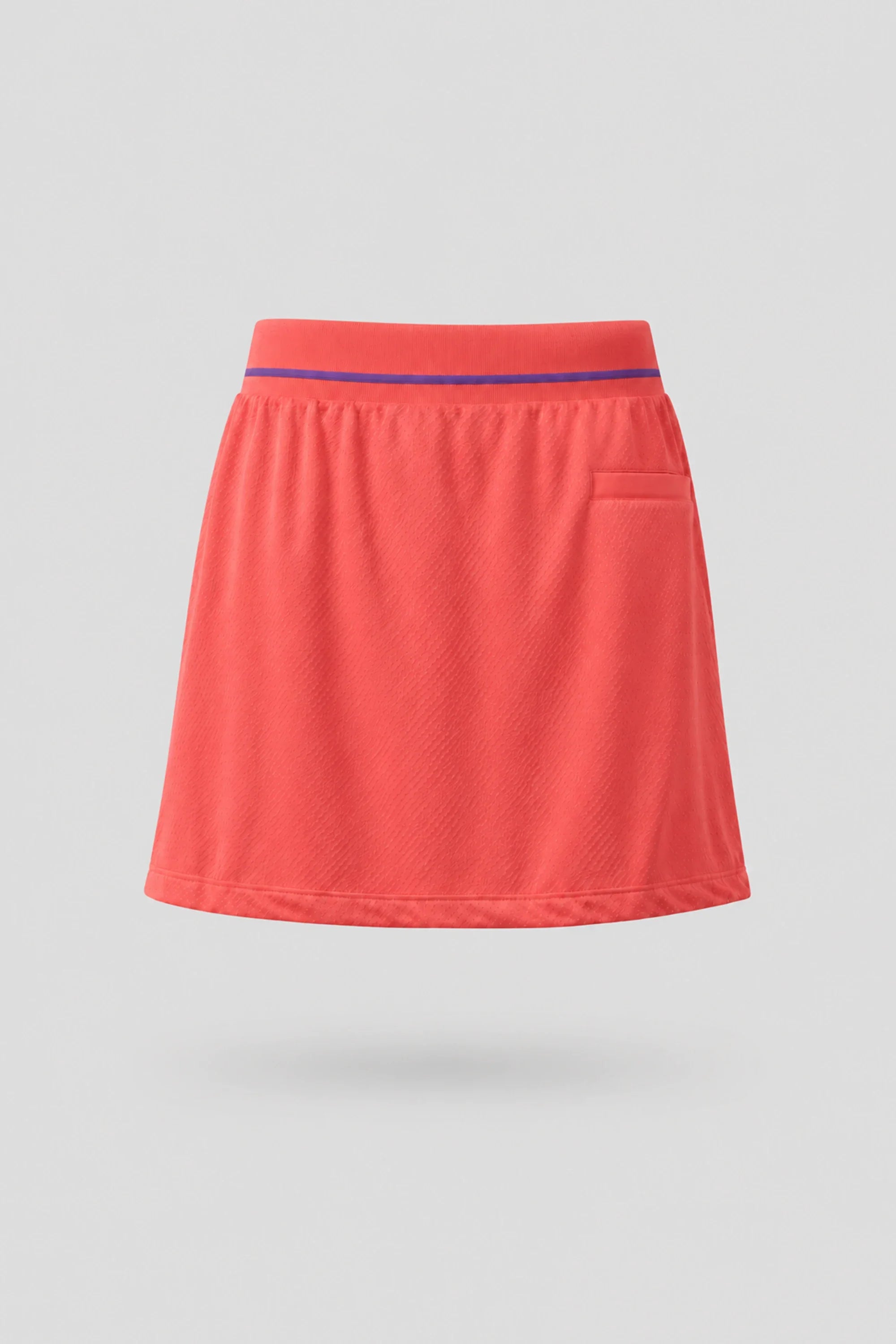 Back view of women's coral red golf skort with lightweight stretch fabric and flattering fit