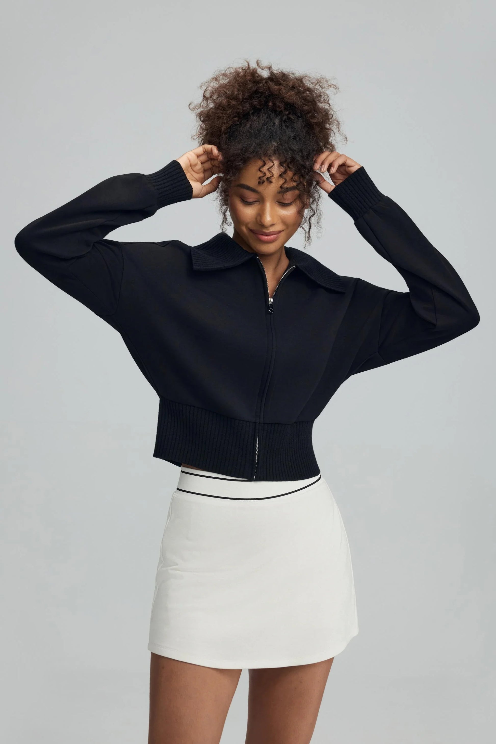 Women’s black cropped knit zip jacket with ribbed waistband and zip front