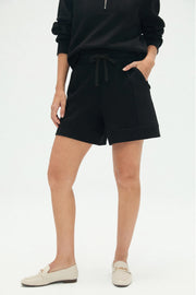Front view of women’s black tailored golf shorts with a relaxed structured silhouette