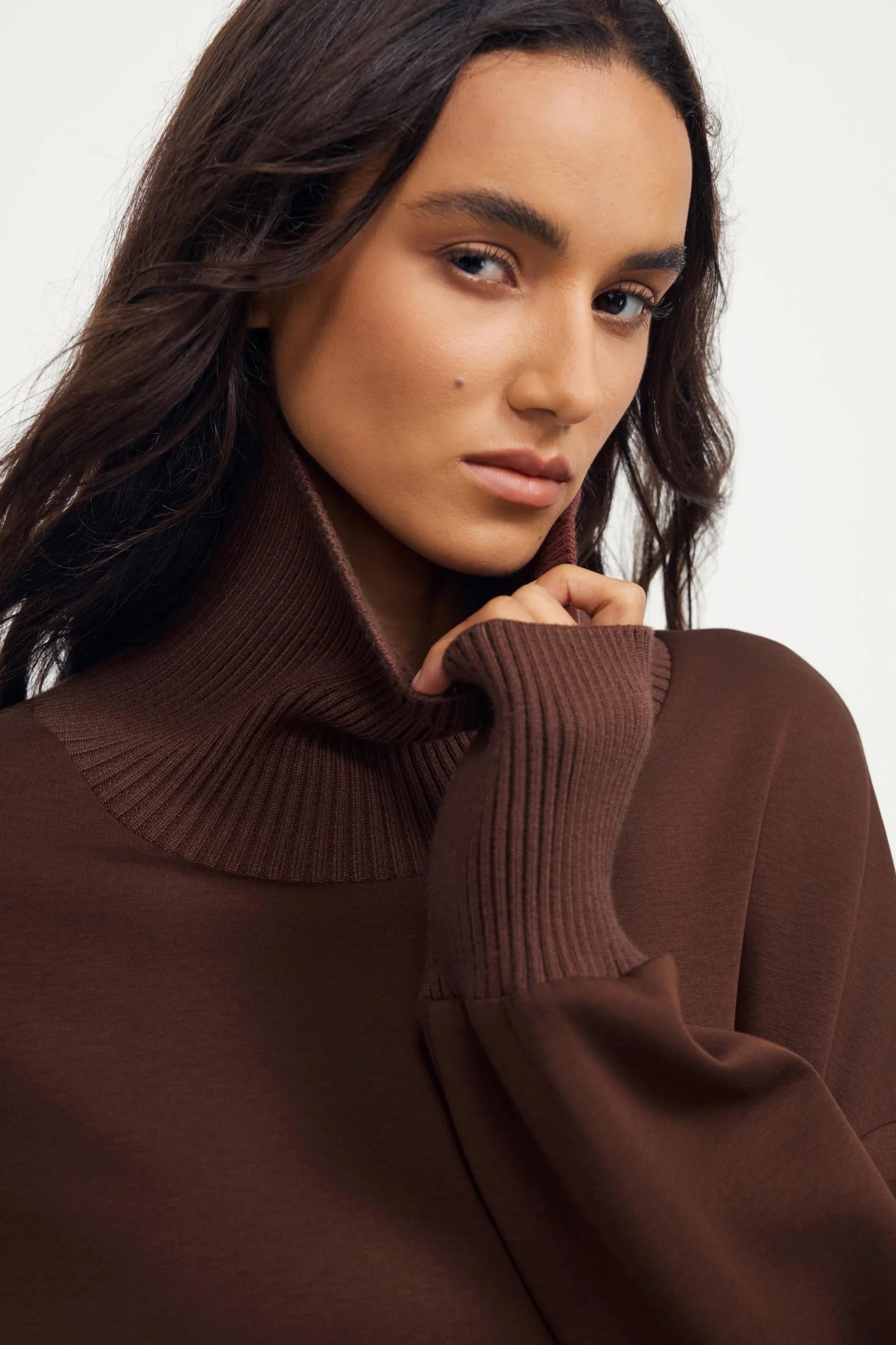 Close-up of women’s brown funnel-neck pullover in soft stretch fabric