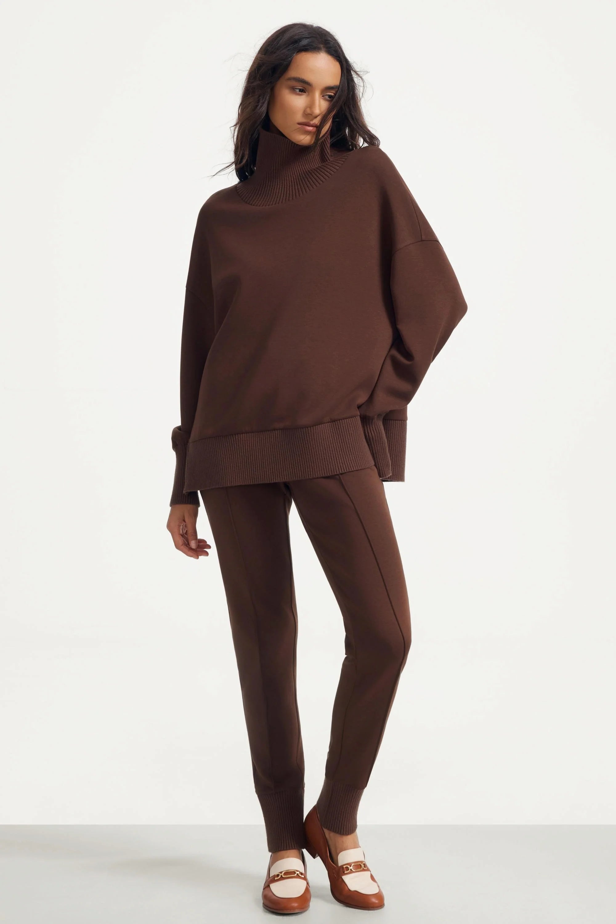 Angled full-body view of women’s brown funnel-neck pullover and matching pants