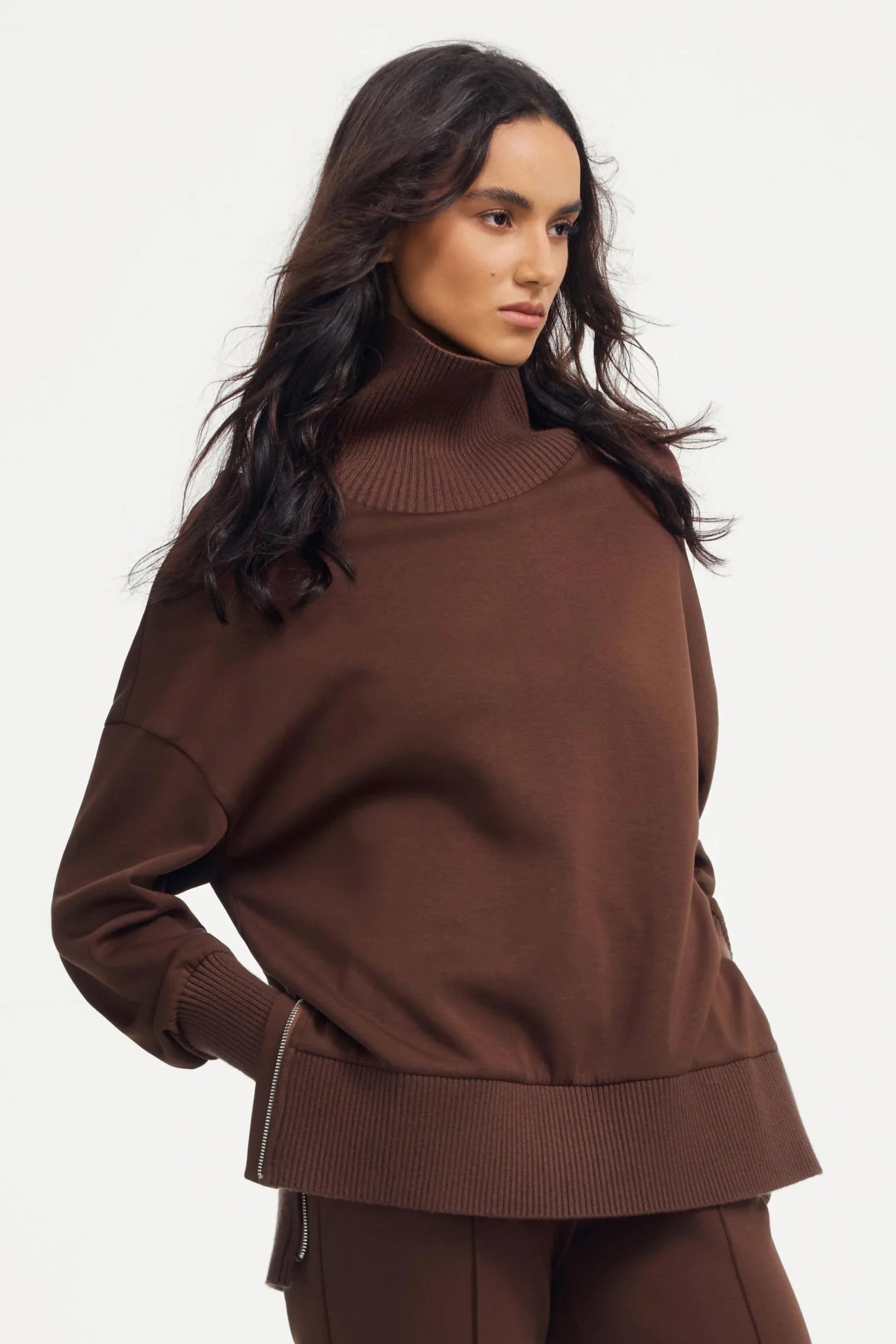 Side view of women’s brown funnel-neck pullover with soft drape and ribbed collar