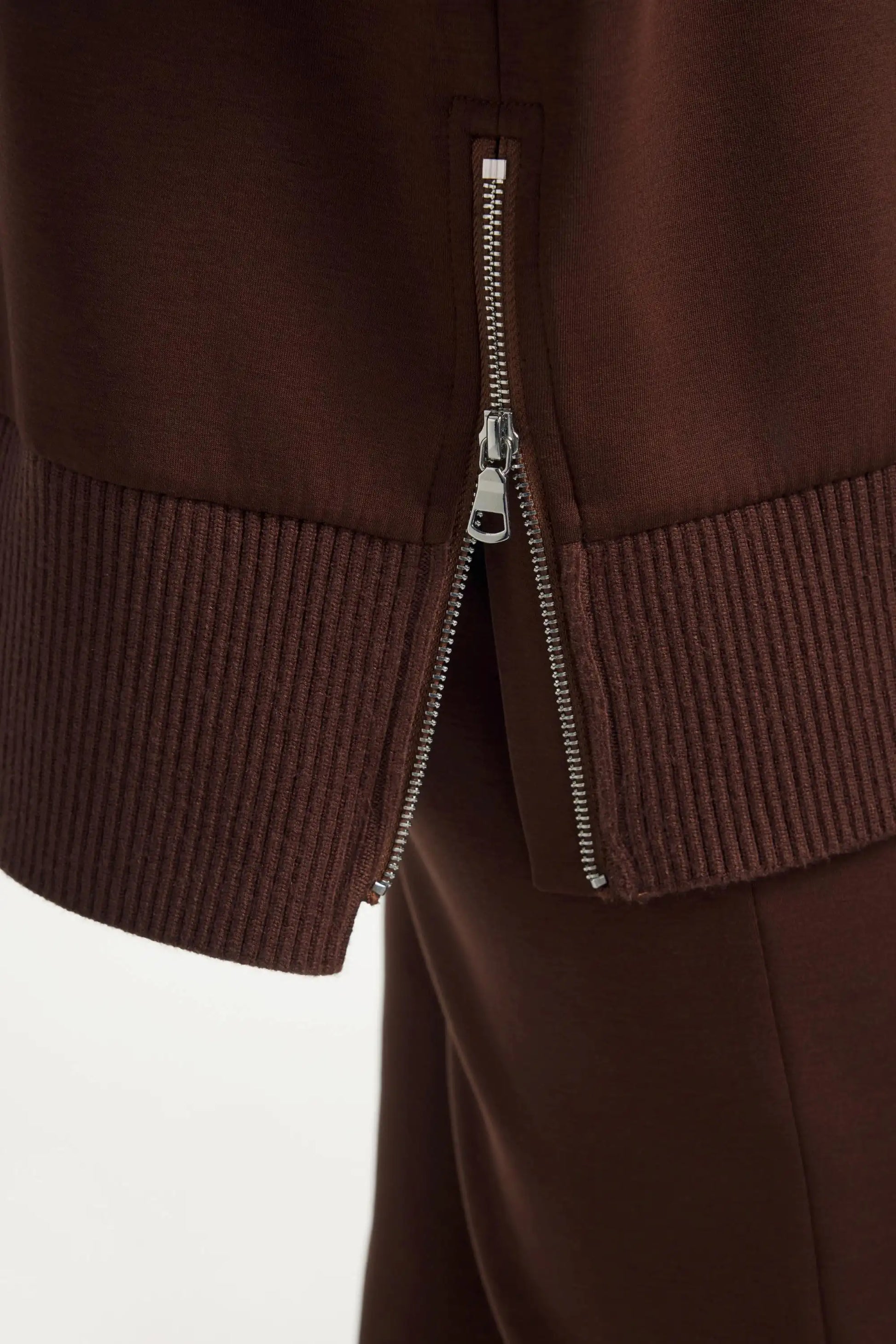 Side zipper detail on women’s brown funnel-neck pullover