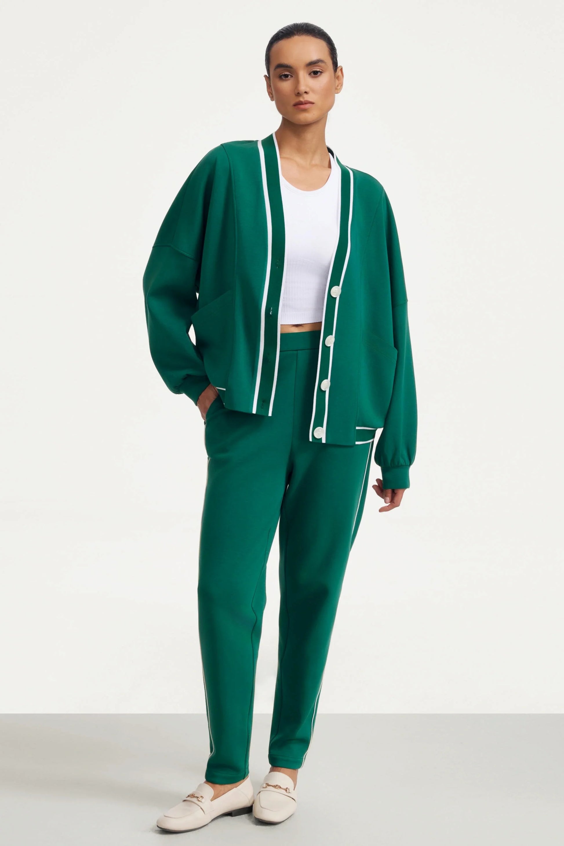 Full look of a woman wearing a deep teal button cardigan with matching slim pants