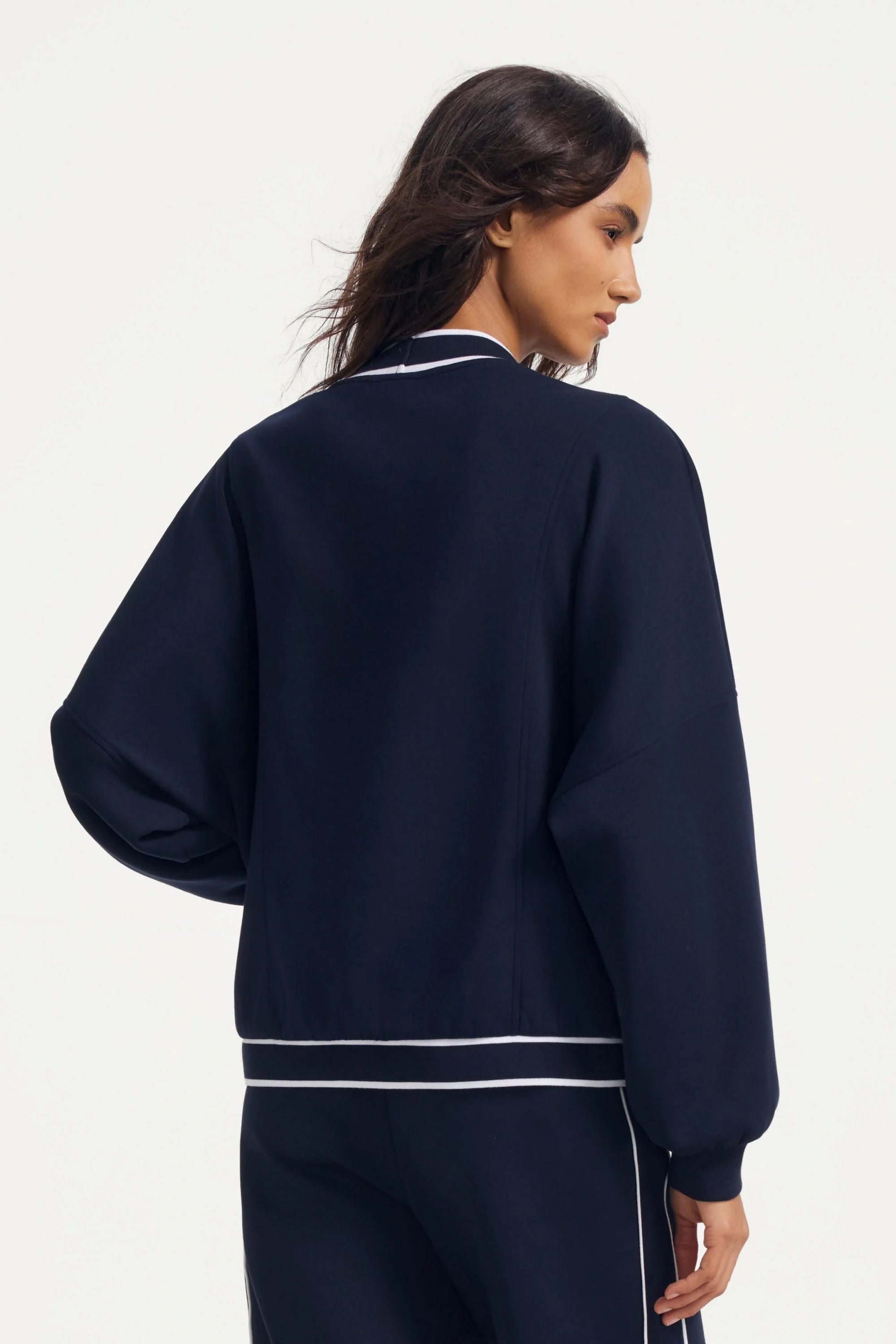 Back view of a midnight navy women’s button cardigan with contrast trim