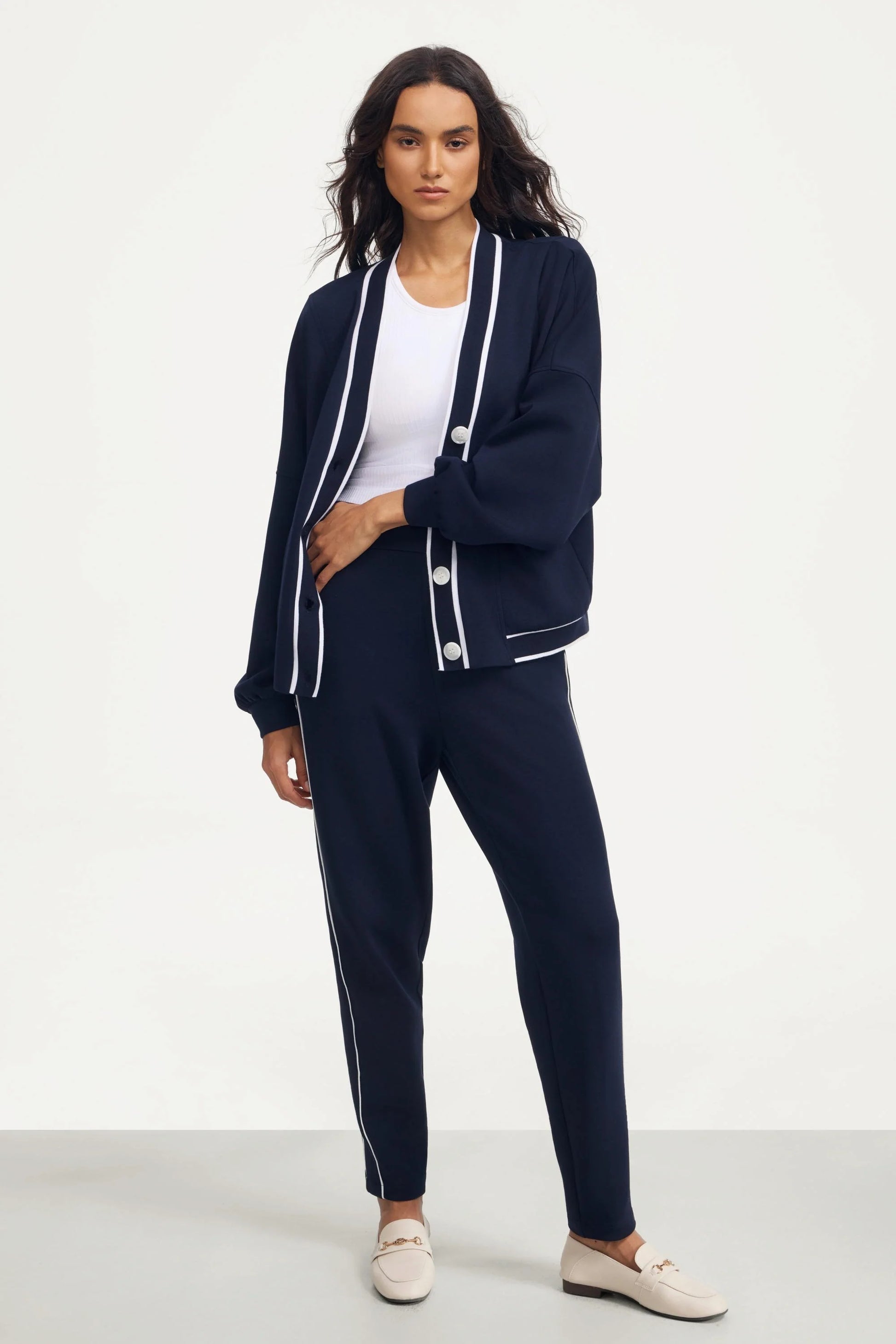 Woman wearing a midnight navy button cardigan styled with matching slim pants