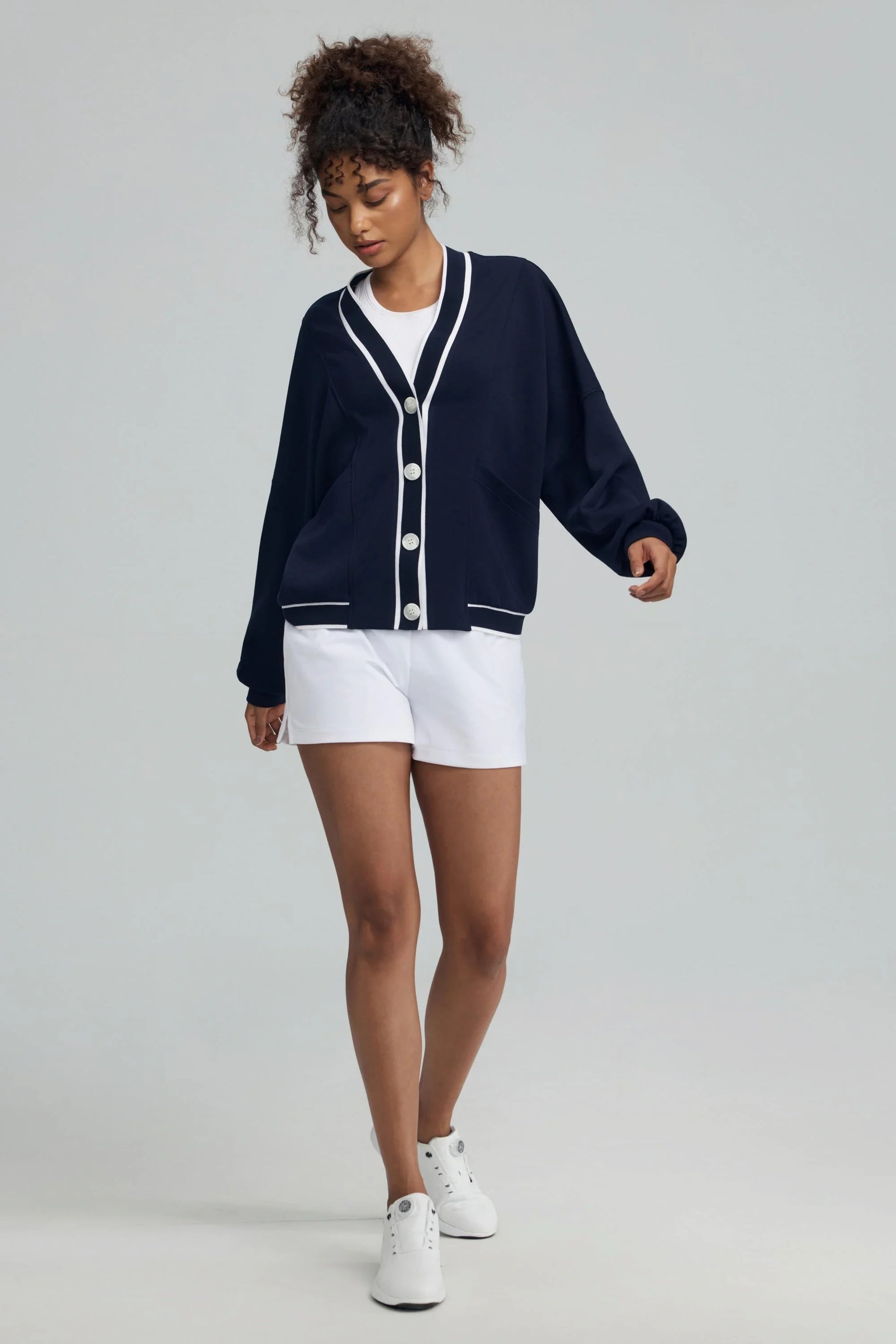 Midnight navy women’s button cardigan styled with white athletic shorts