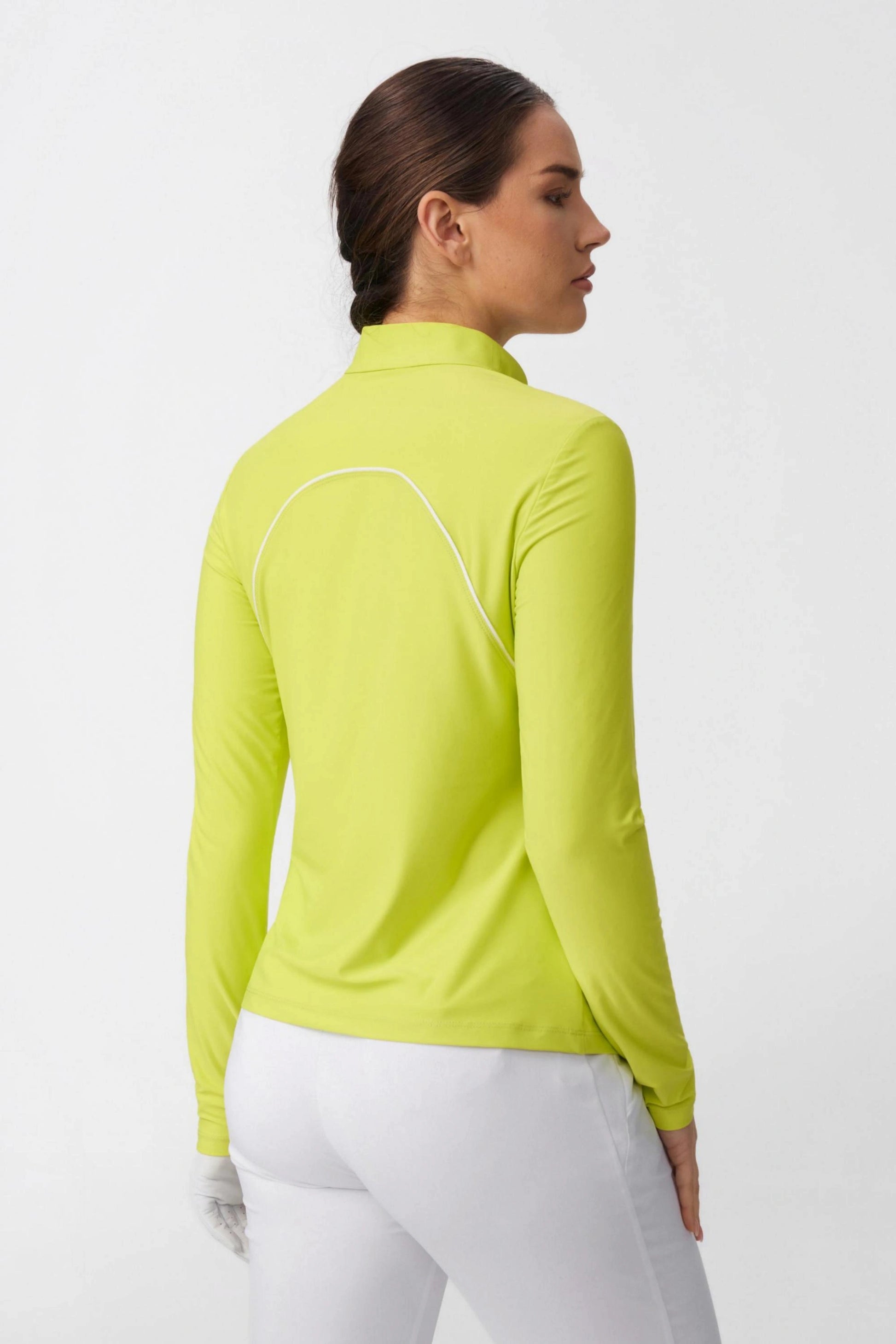 Back view of women’s citron quarter-zip golf top highlighting curved contrast piping and streamlined fit