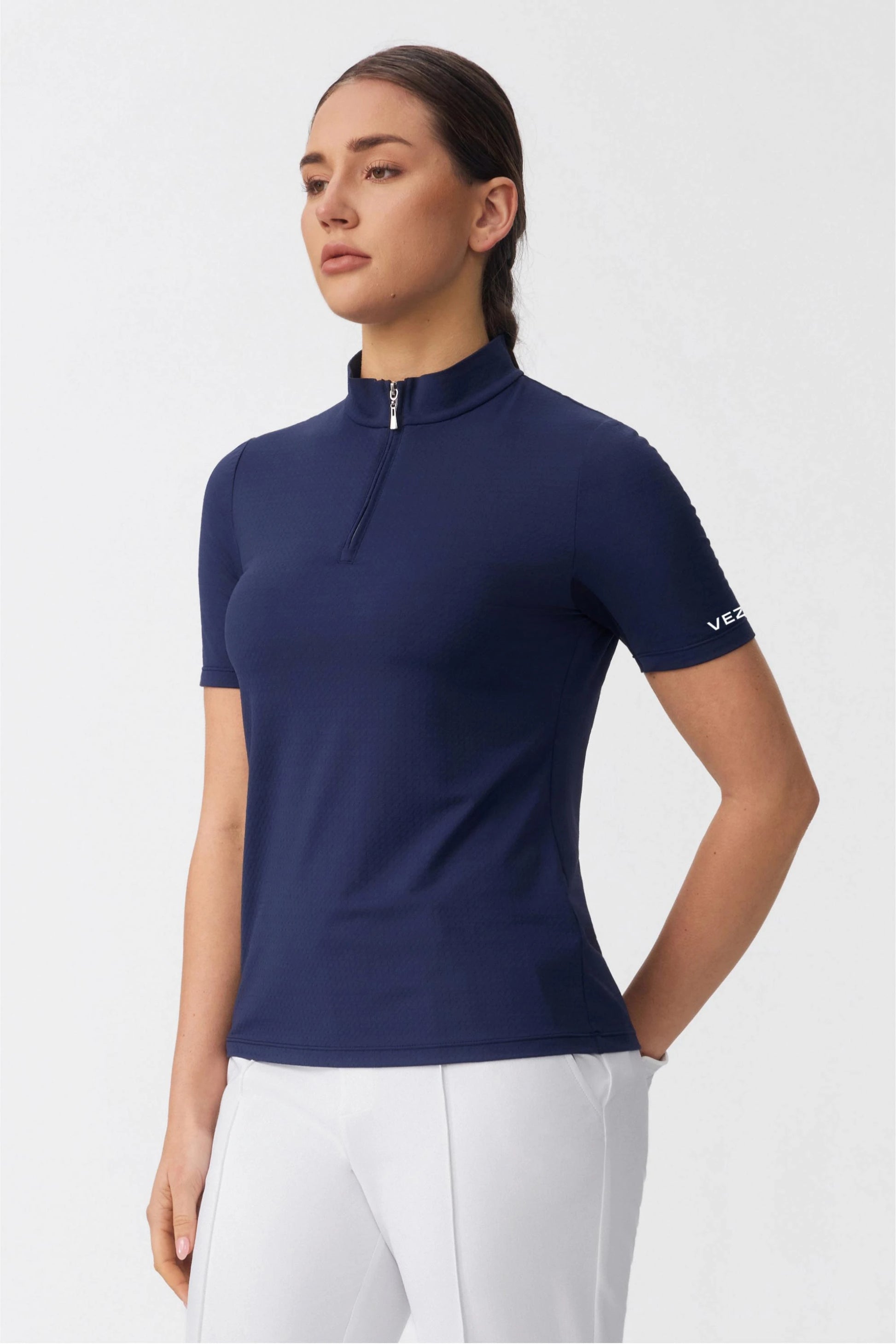 Side view of a navy quarter zip golf top highlighting the contoured fit