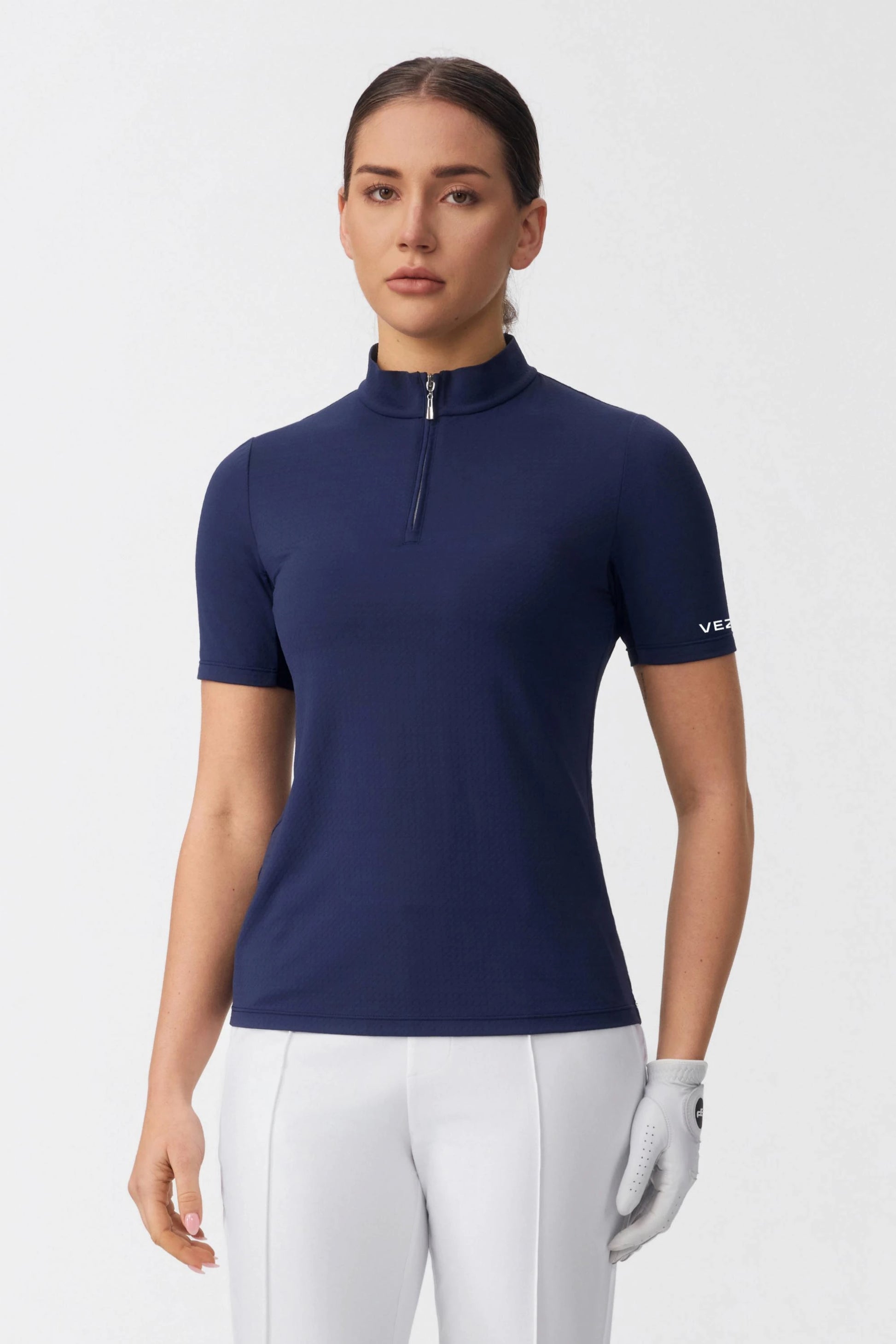 Model wearing a navy zip neck golf top with a streamlined athletic fit