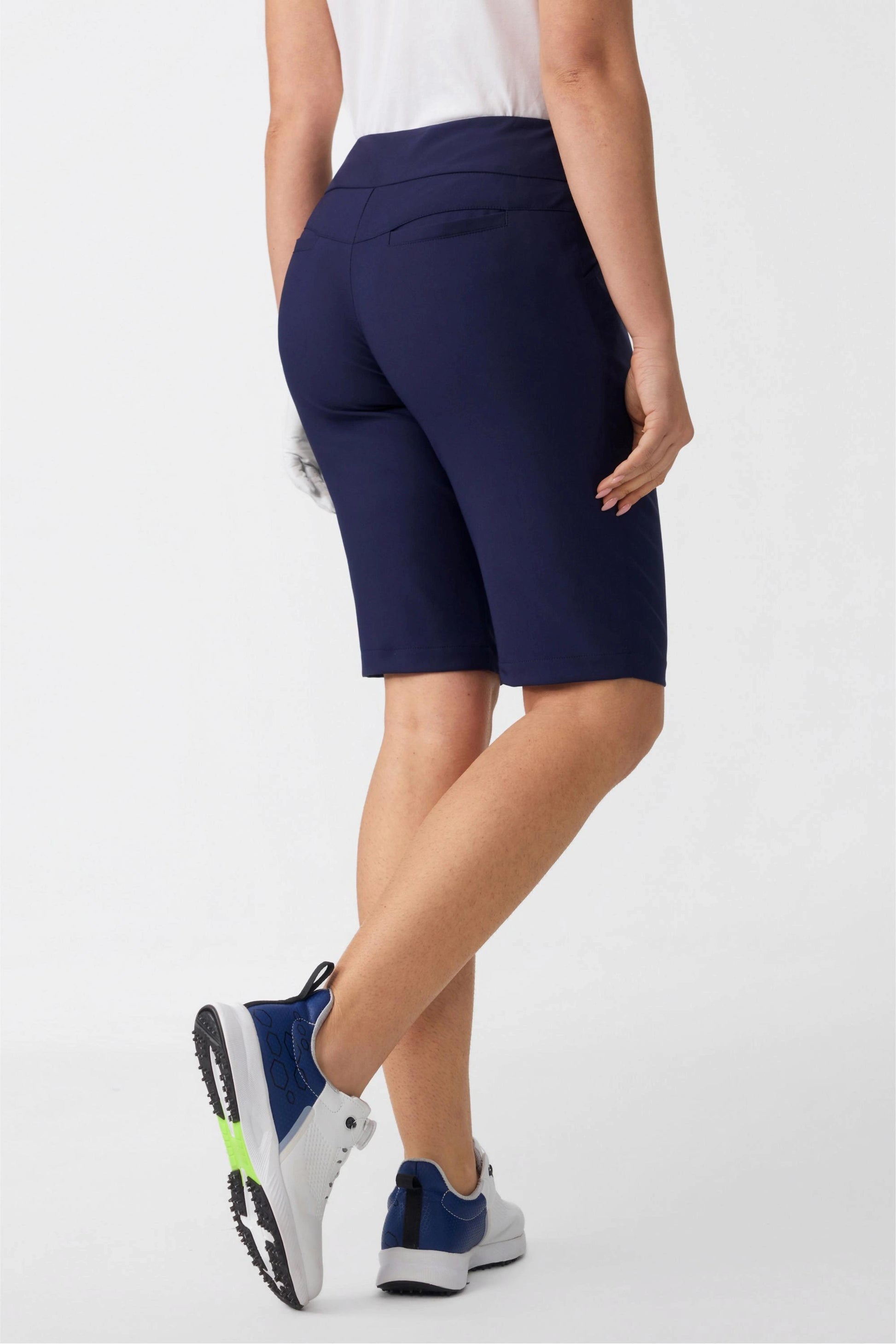 Back angled view of women’s midnight navy tailored golf shorts featuring a sculpted fit and back pocket detail