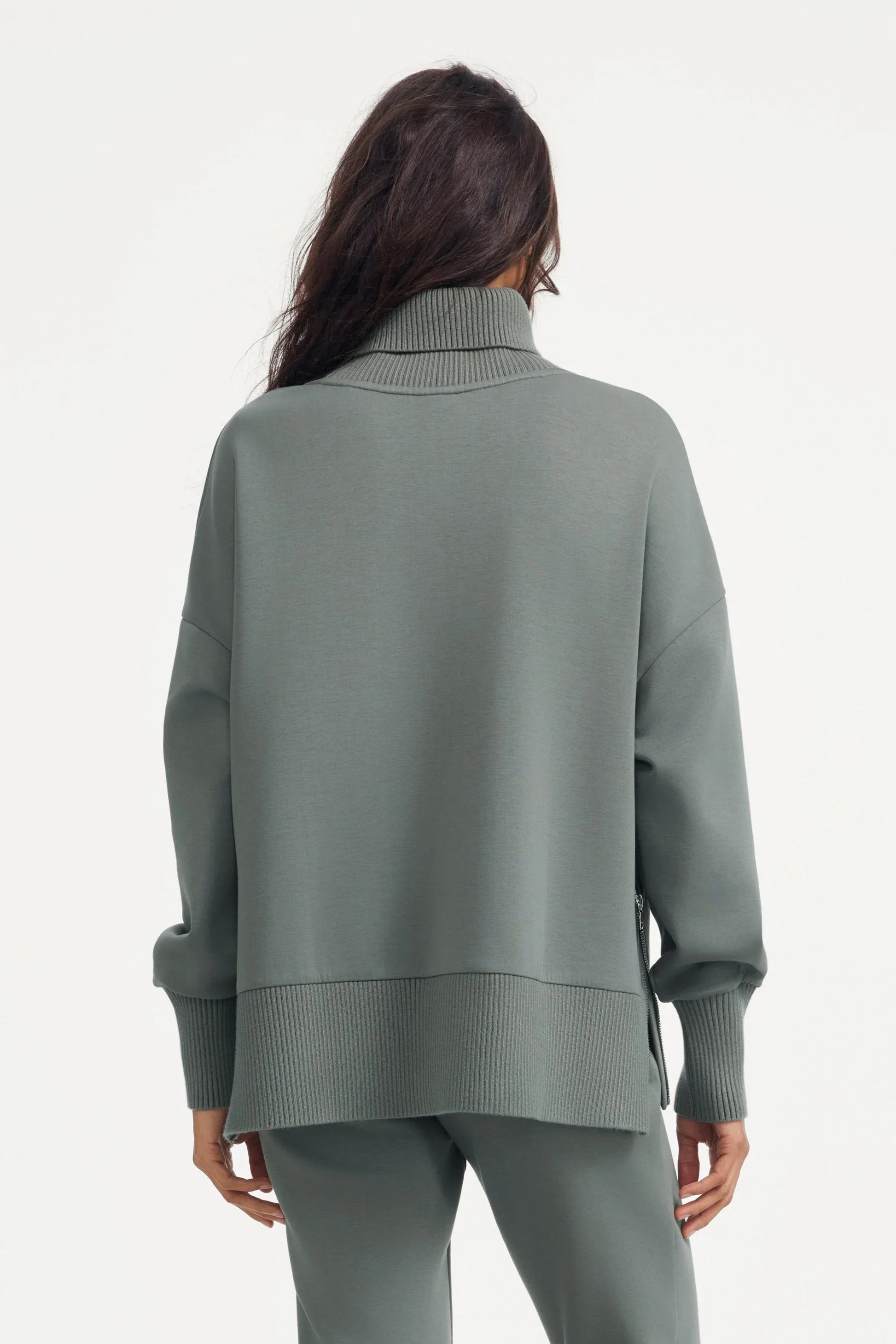 Back view of women’s sage grey funnel-neck pullover with relaxed silhouette