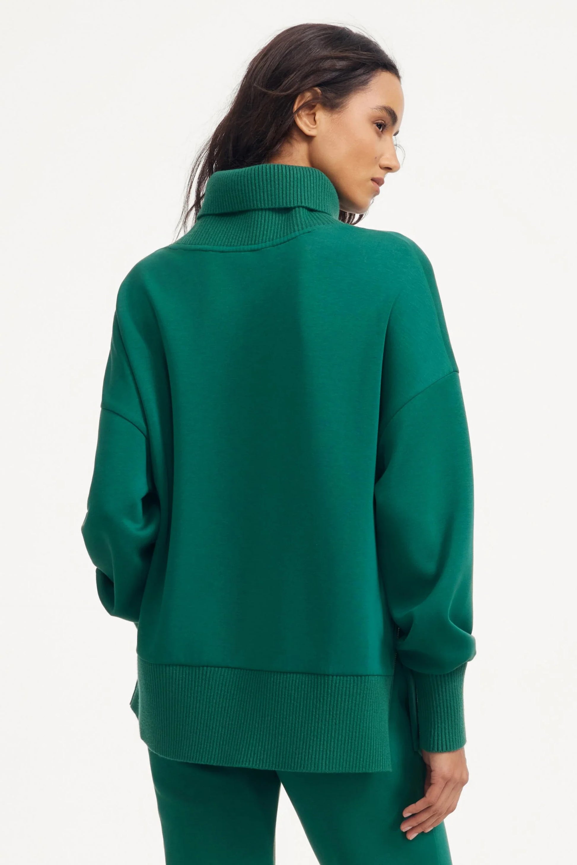 Back view of women’s green funnel-neck pullover with relaxed fit