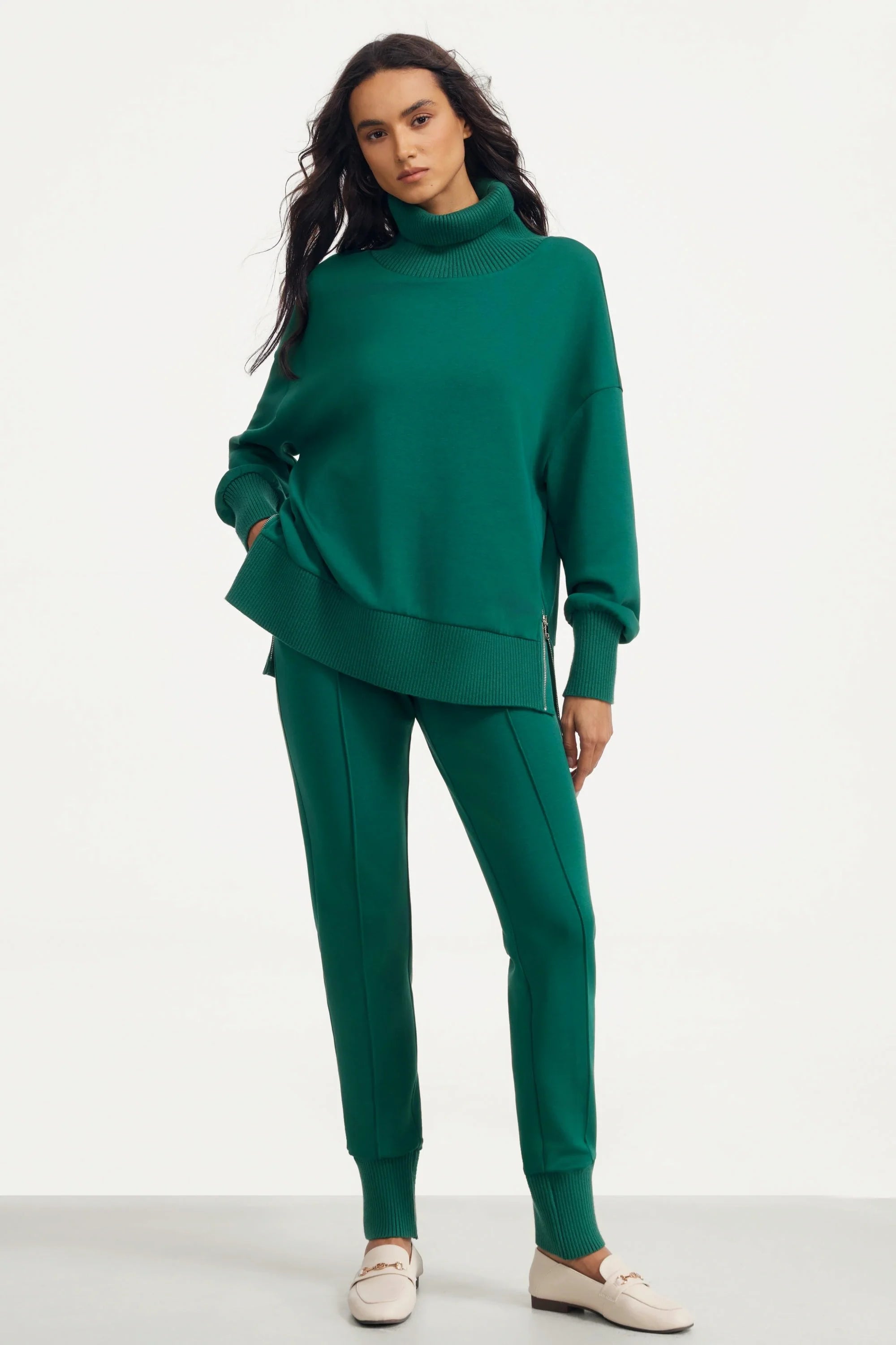 Angled full-body view of women’s green funnel-neck pullover and matching pants