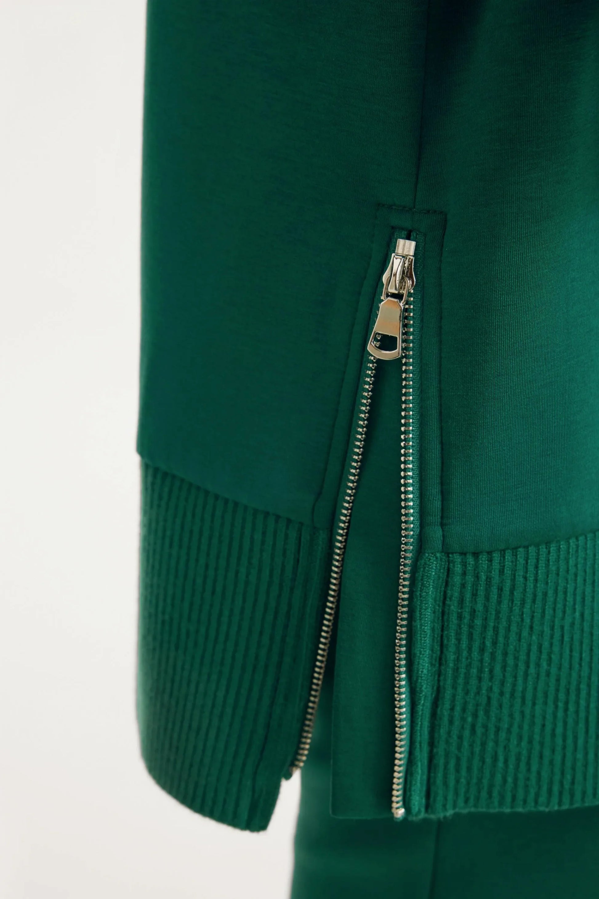 Side zipper detail on women’s green funnel-neck pullover