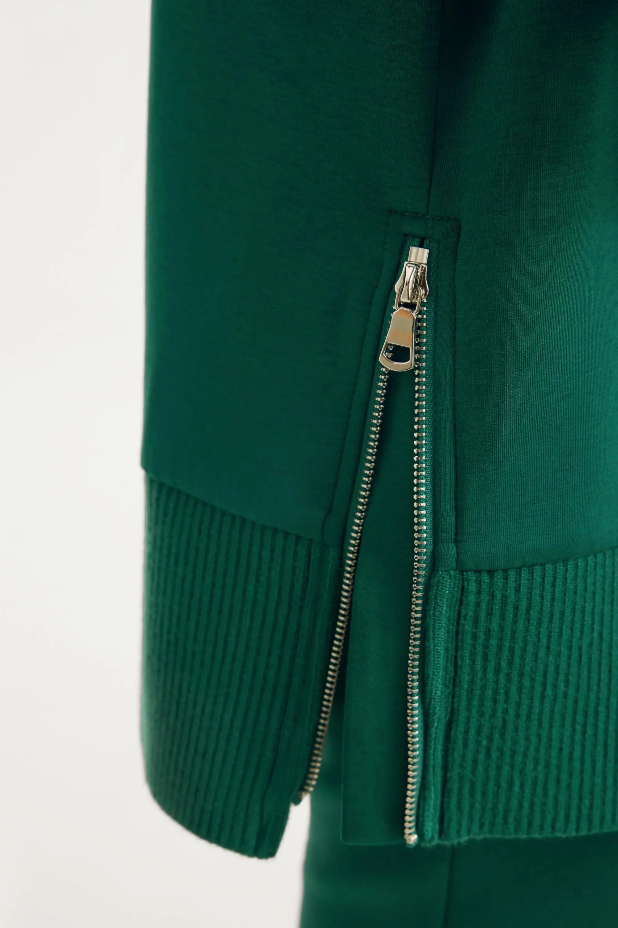 Side zipper detail on women’s green funnel-neck pullover