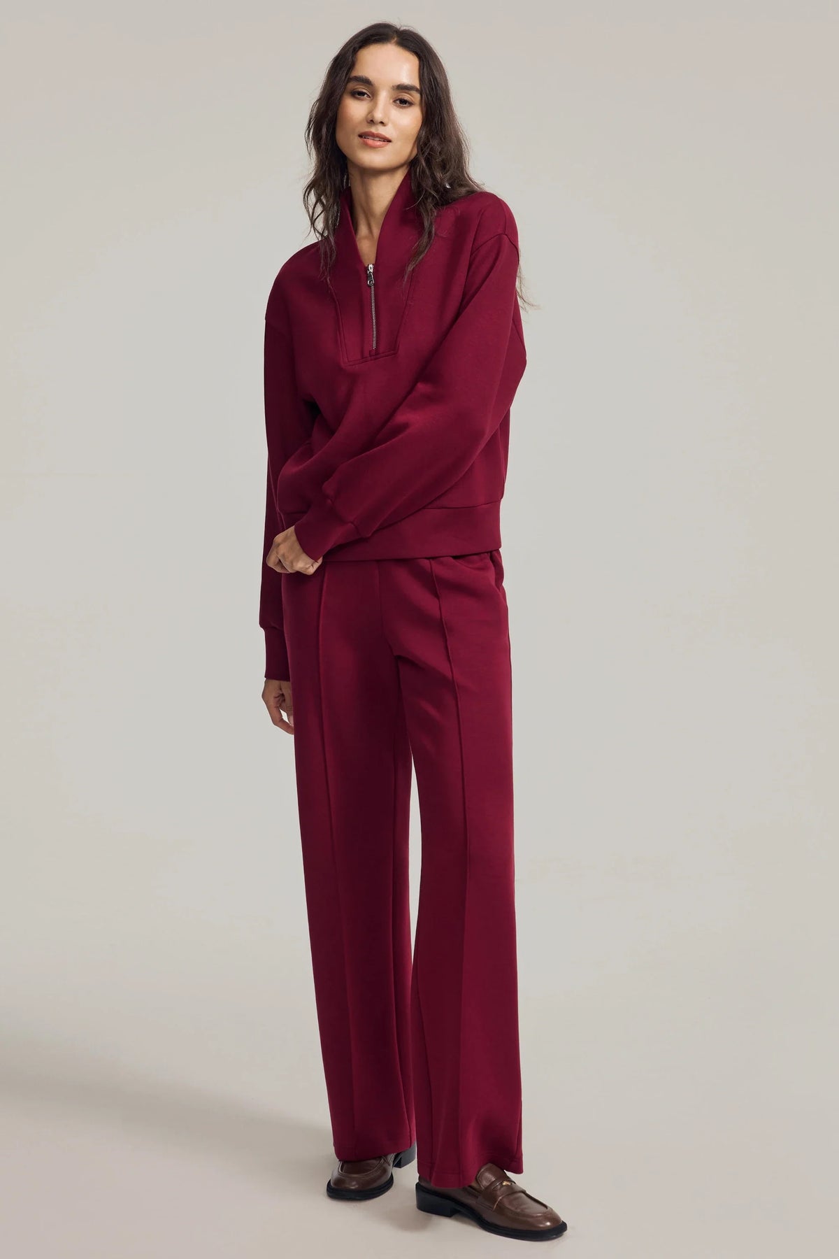 Woman wearing a Burgundy Wine half-zip golf pullover styled with matching straight-leg pants for a coordinated look