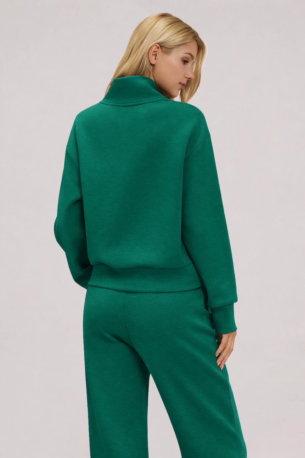 Back view of women's dark green half-zip golf pullover showing the relaxed fit and dropped shoulders