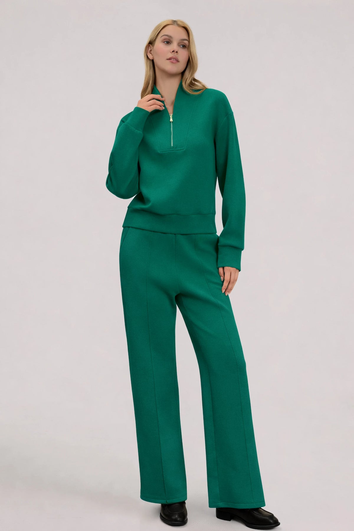 Woman wearing a Deep Teal half-zip golf pullover styled with matching straight-leg pants for a coordinated look