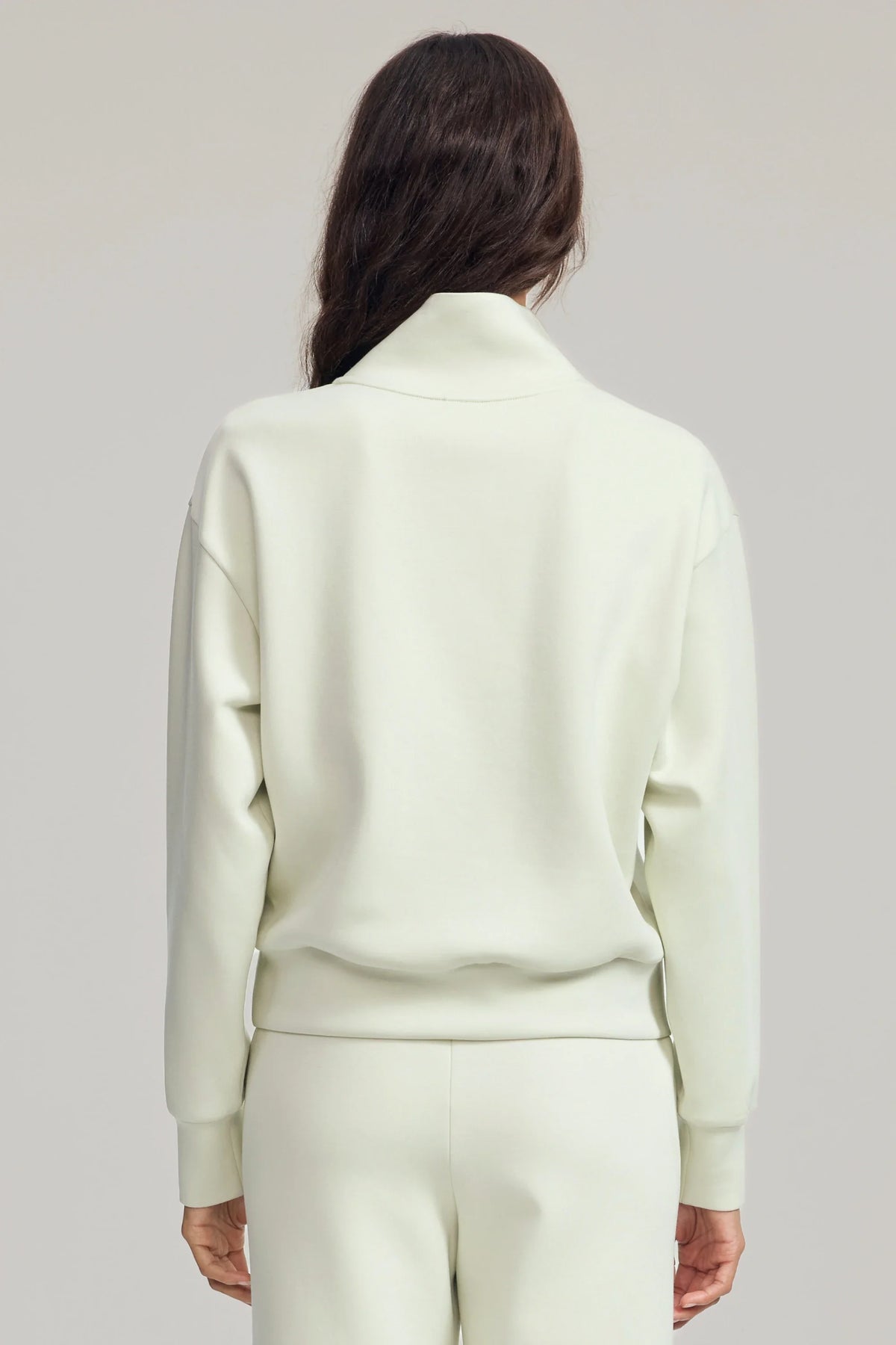 Back view of women's Pistachio Cream half-zip golf pullover with a relaxed silhouette, dropped shoulders and clean hem