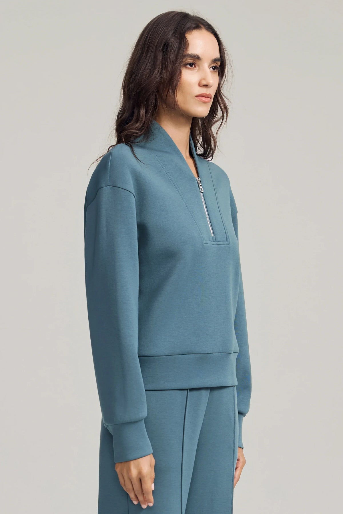 Side view of women's Slate Blue half-zip golf pullover showing the soft stand collar, dropped shoulders and relaxed fit