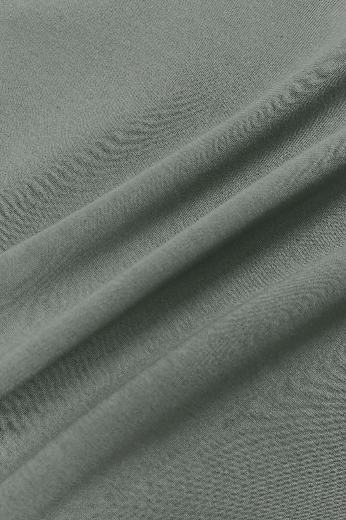 Close-up of the soft sage grey fabric texture on the women’s knit polo sweatshirt